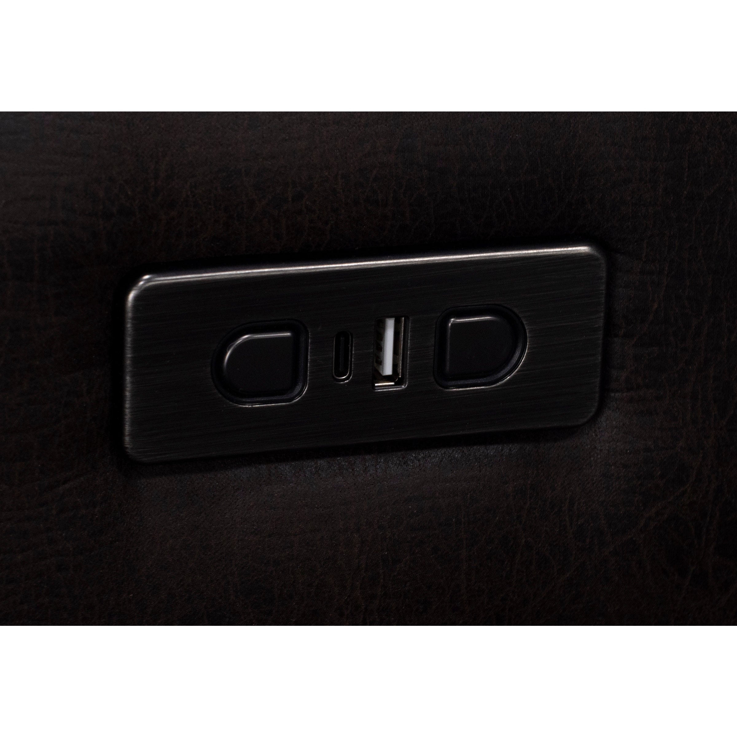 Close-up of a built-in USB and power port panel on dark upholstered furniture.