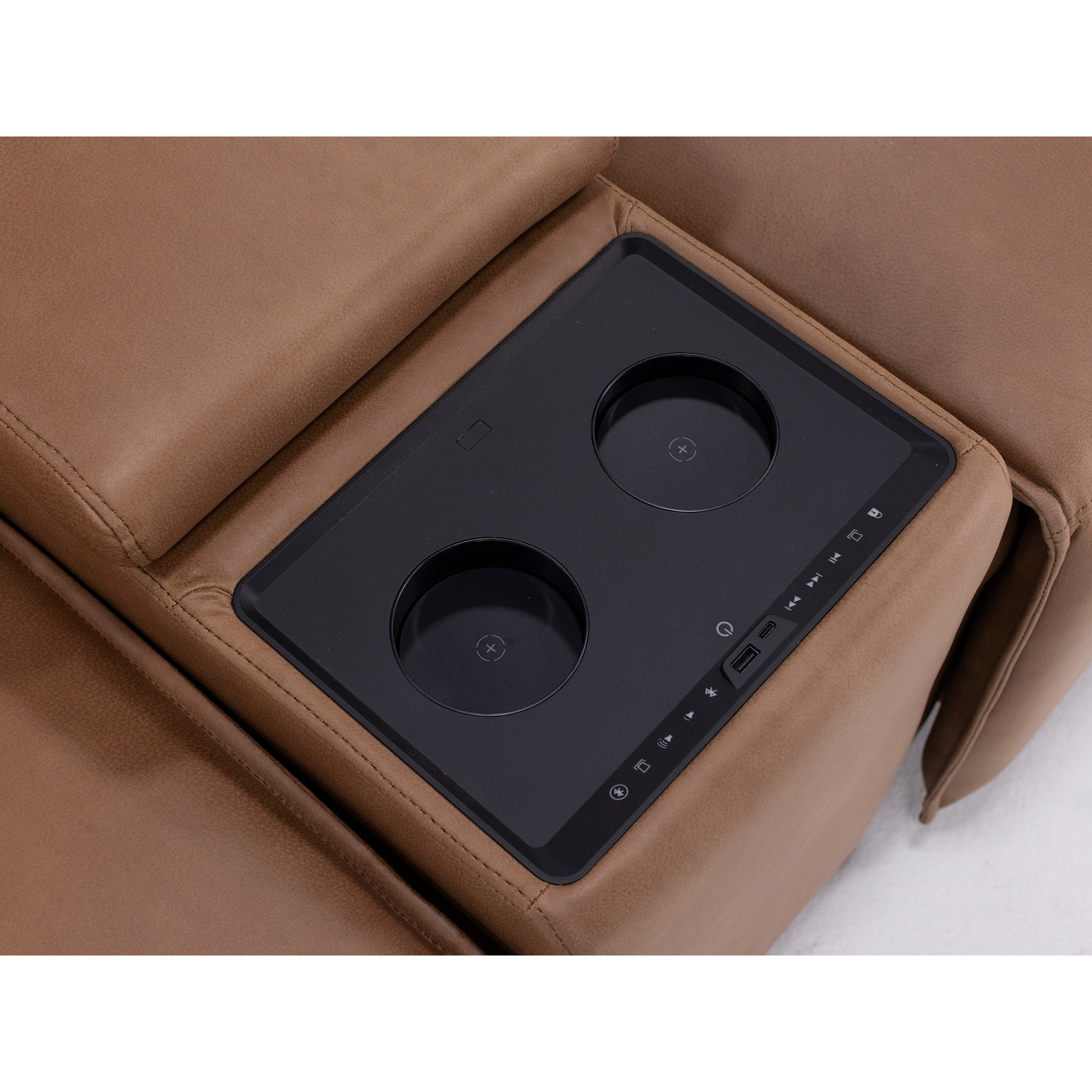 Close-up of built-in cup holders and control panel on brown leather recliner armrest.