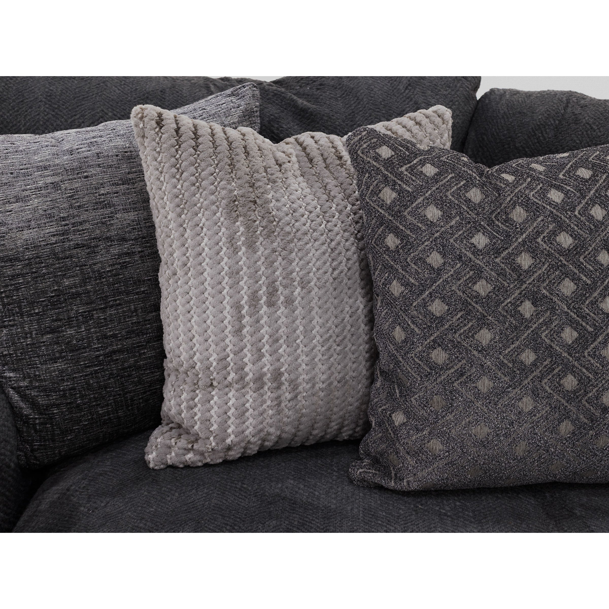 Close-up of two textured grey throw pillows on a dark fabric sofa.