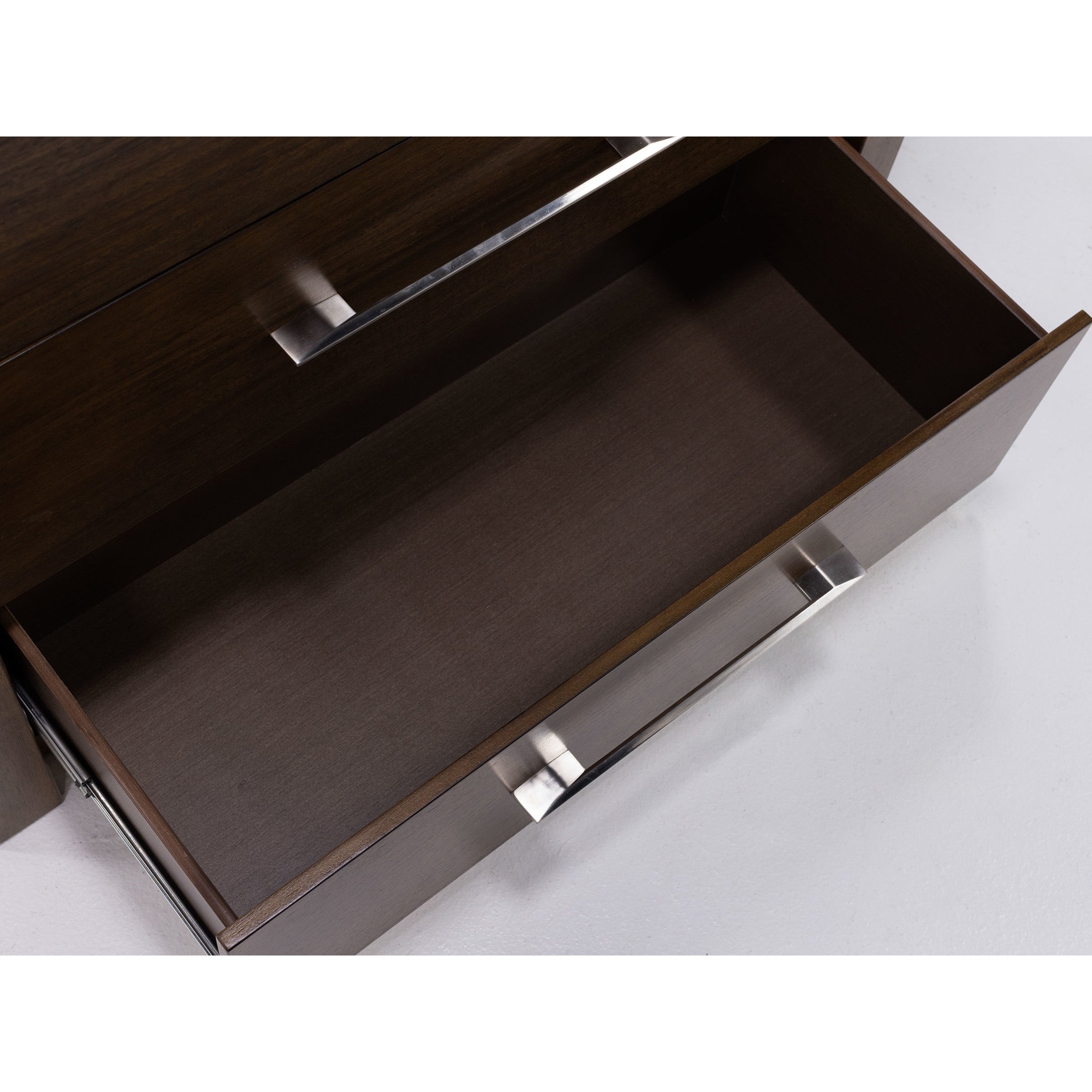 Open, empty drawer with metal handles, shown from above.