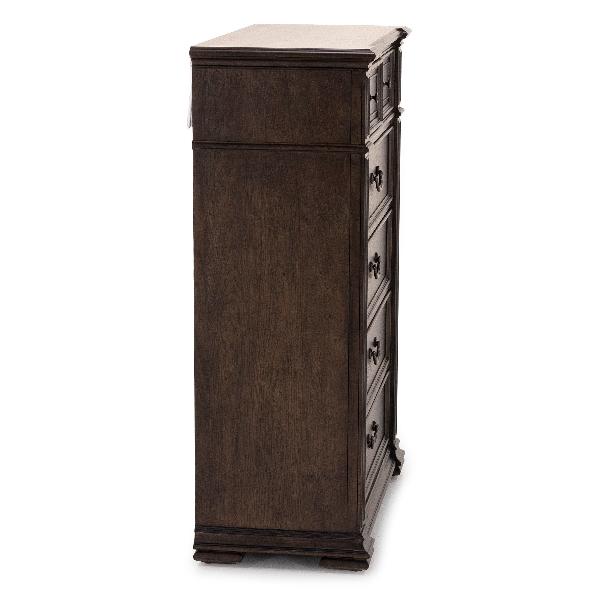 Side view of a tall, dark wood chest of drawers with classic handles.