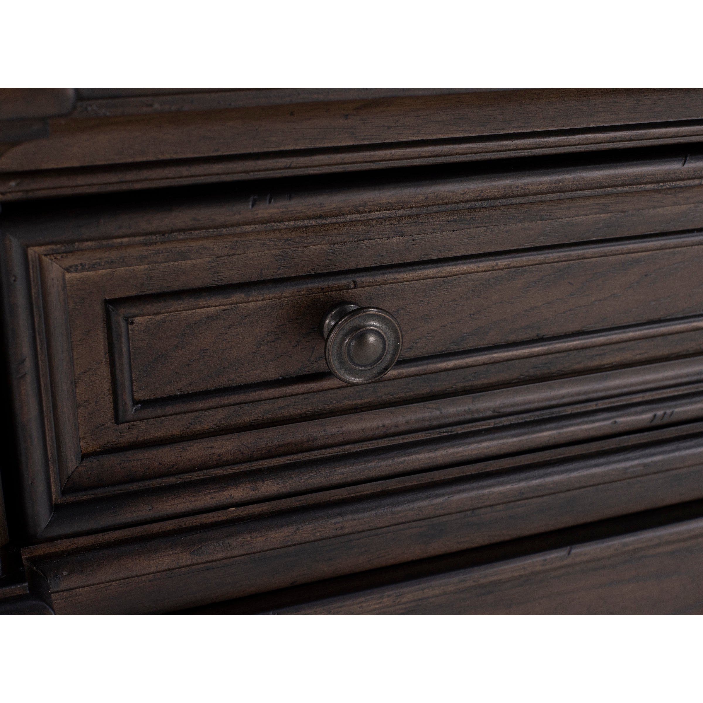 Close-up of a dark wood drawer with a round metal knob.