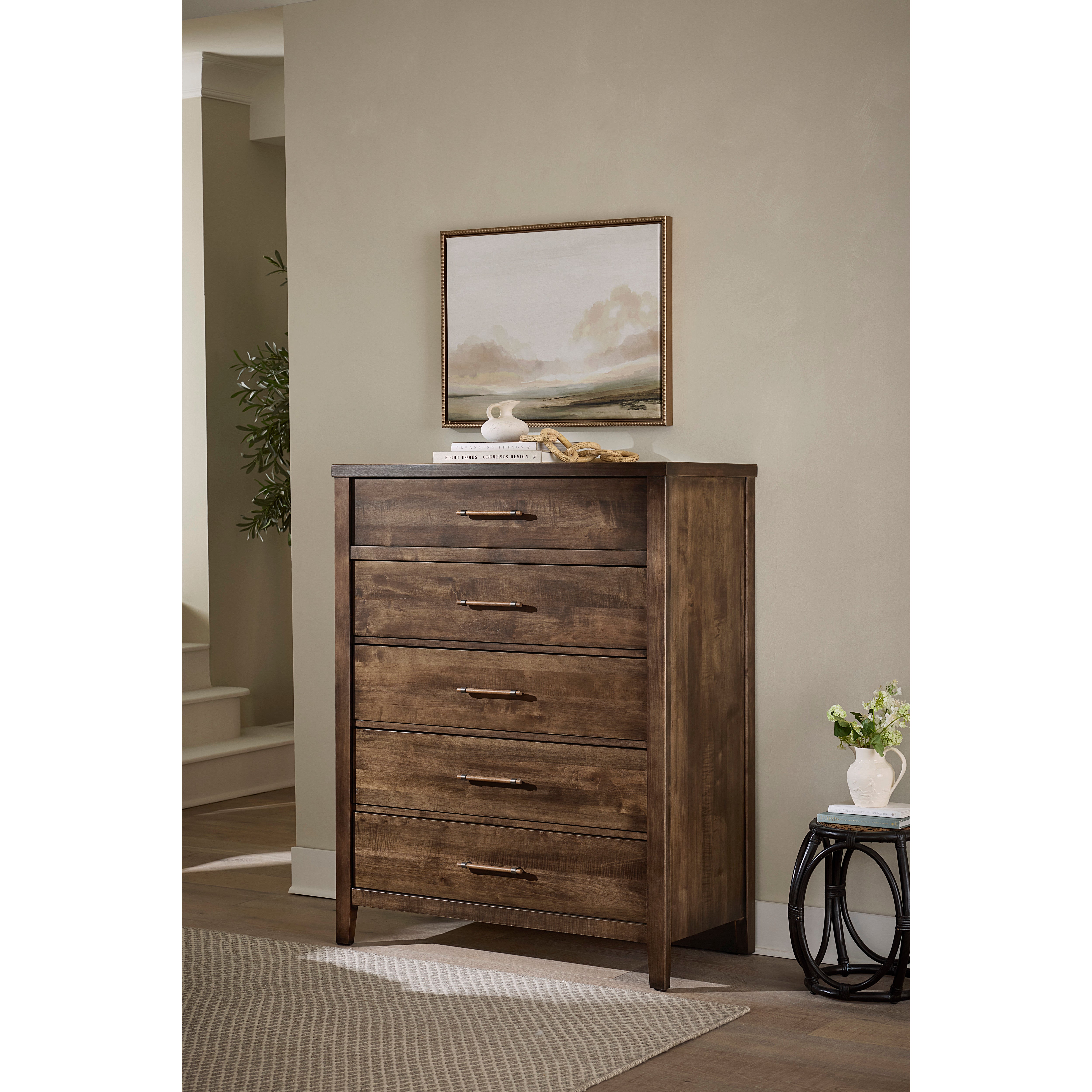 Dark wood chest of drawers in a room with neutral decor and a landscape painting above.