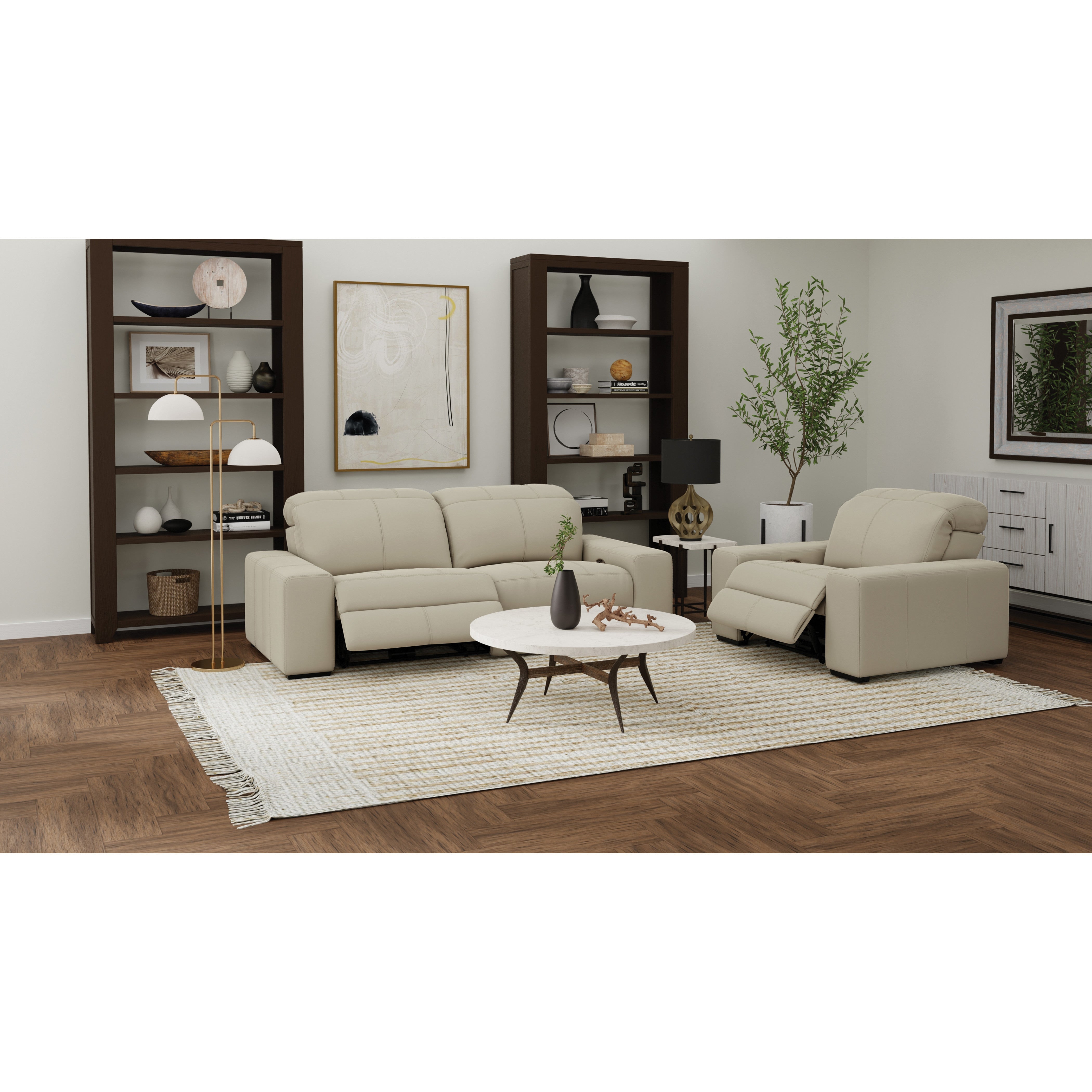 Modern living room with beige sofa, recliner, coffee table, bookshelves, and decorative accents.