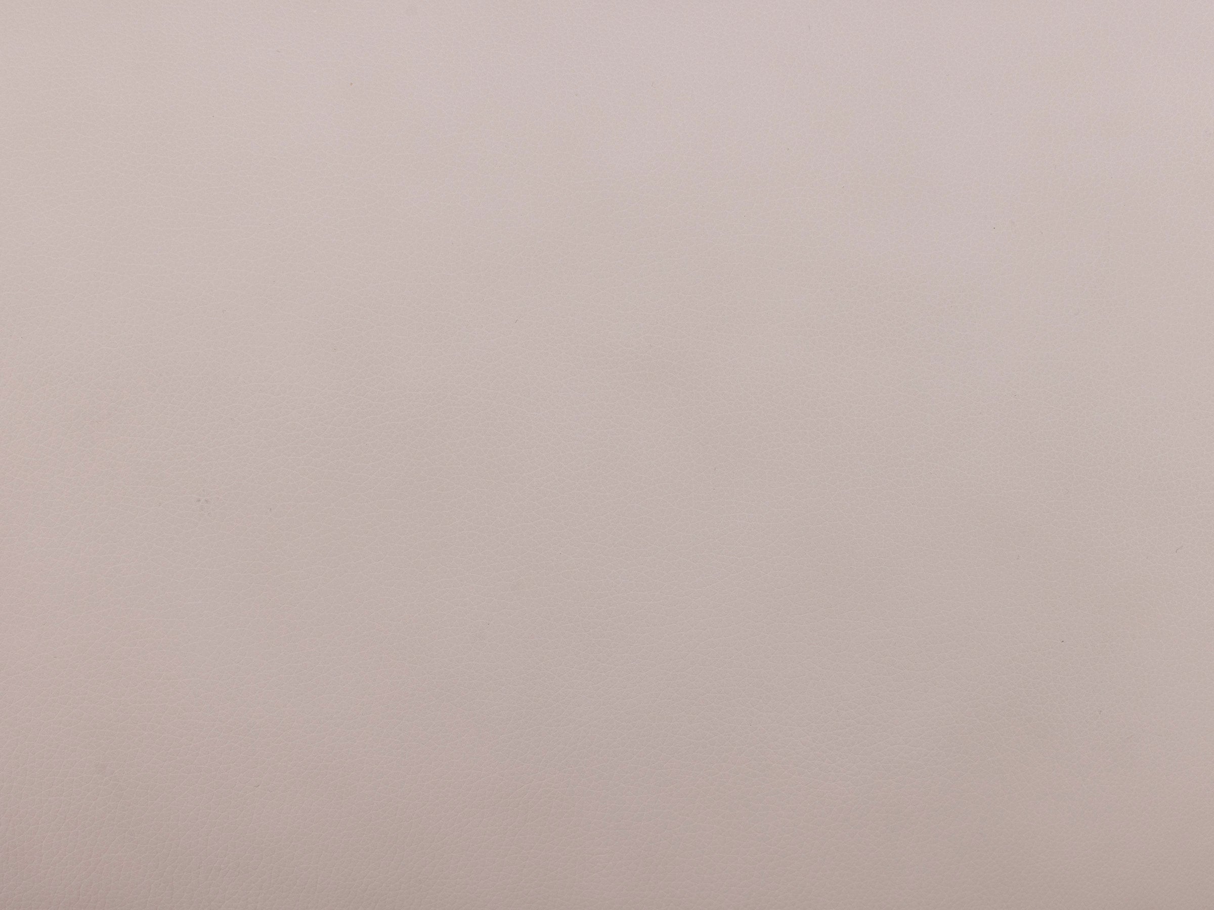 Close-up of light beige leather texture sample.