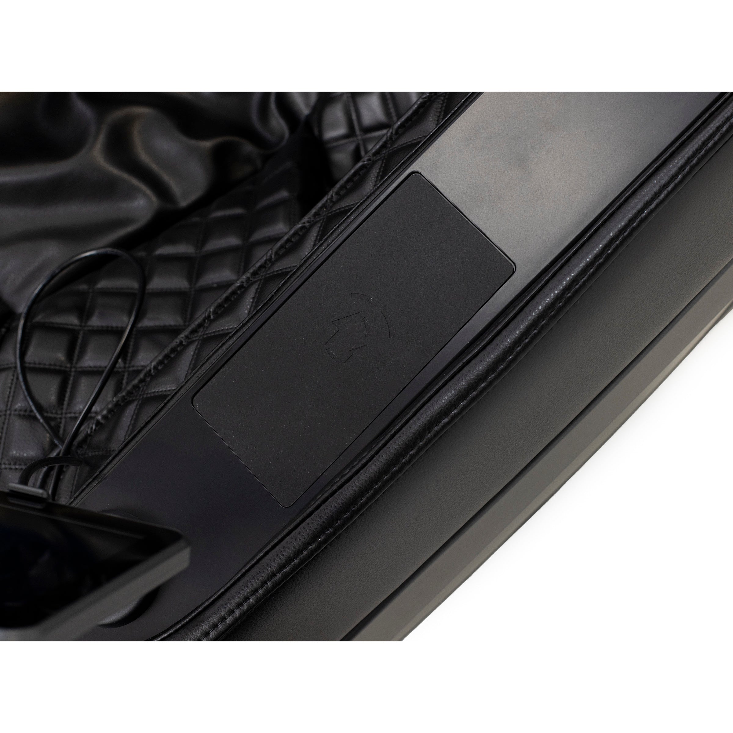 Close-up of a black quilted car seat with a Tesla logo on a plastic panel.