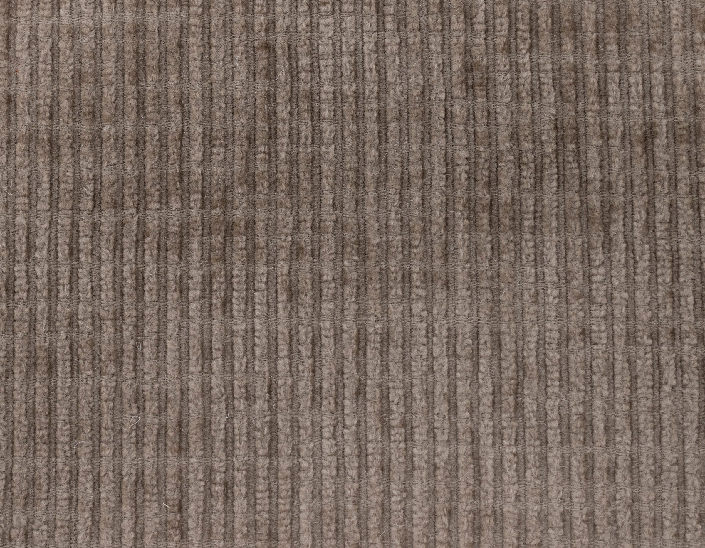 Close-up of textured brown corduroy fabric with vertical ridges.