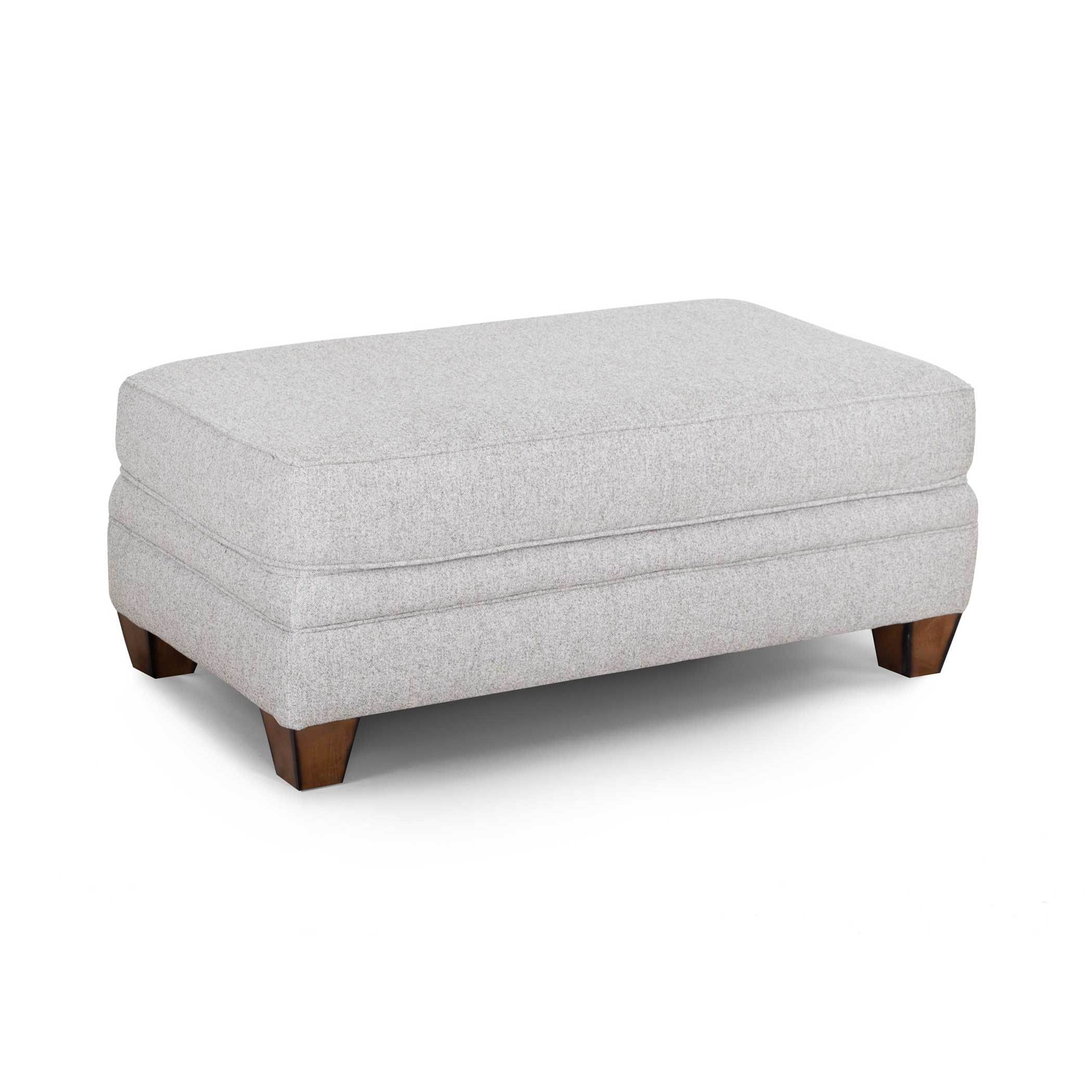 Light gray upholstered rectangular ottoman with wooden legs.