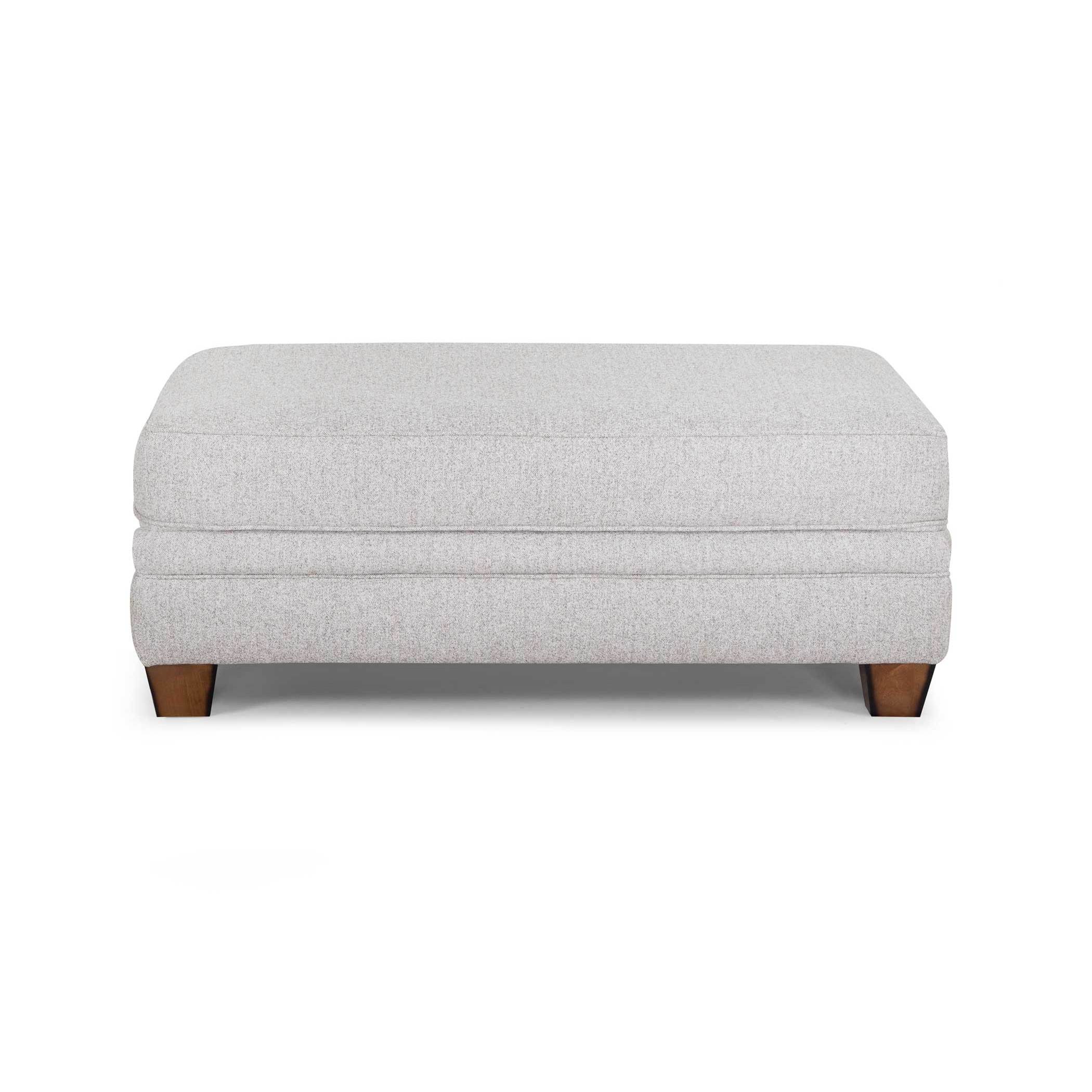 Light gray upholstered ottoman with wooden legs.