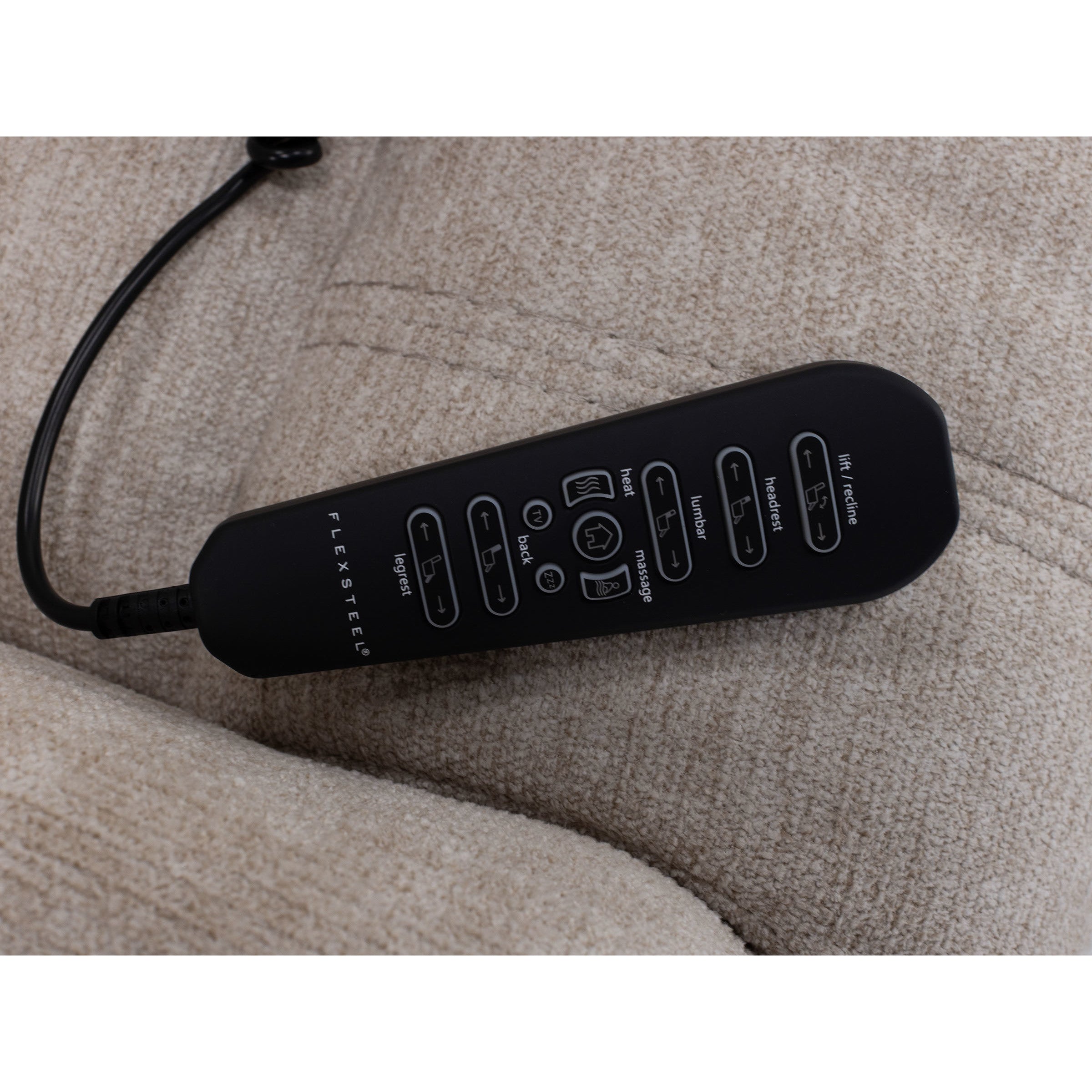 Black remote control for recliner on beige upholstered chair seat.