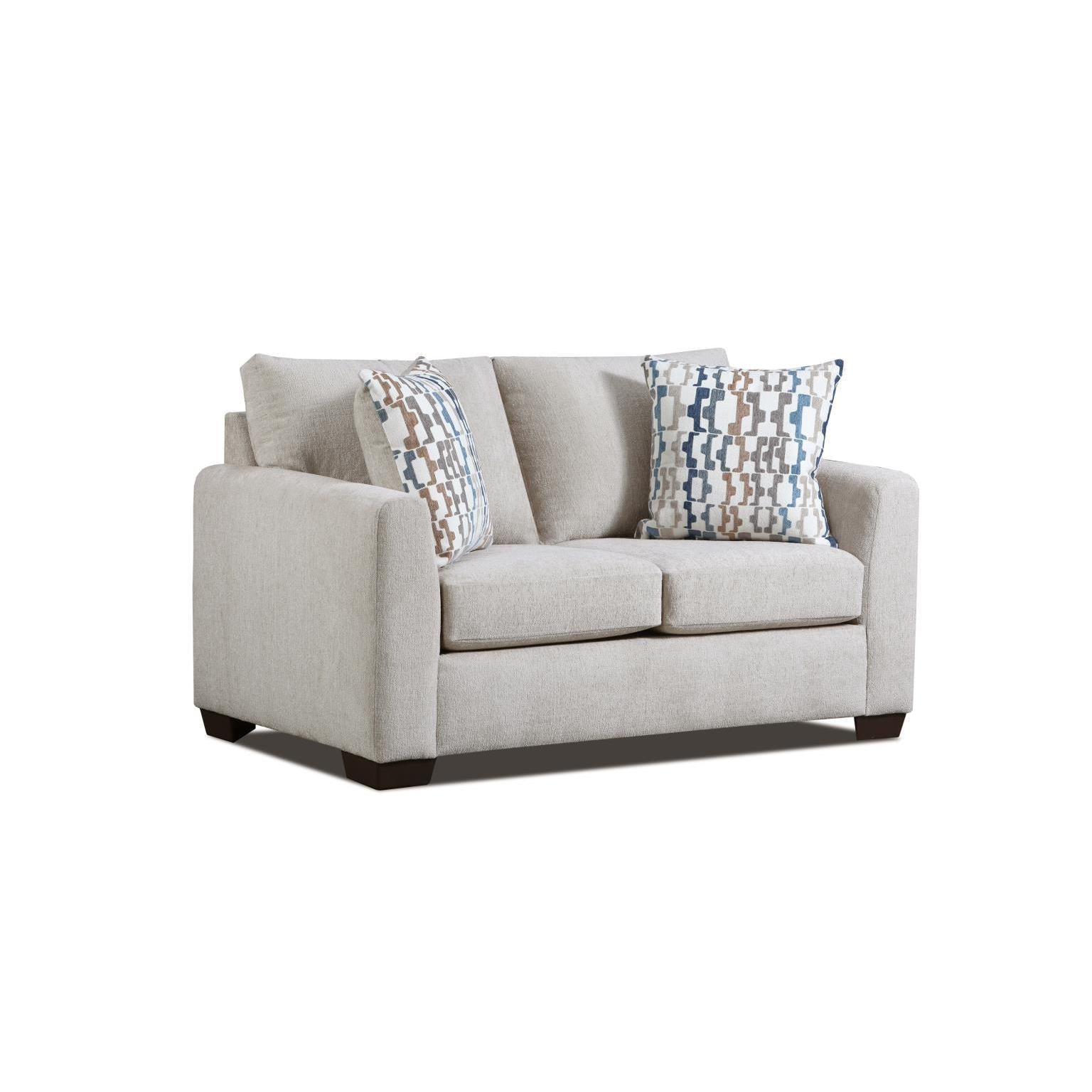 Light beige sofa with two patterned accent pillows.