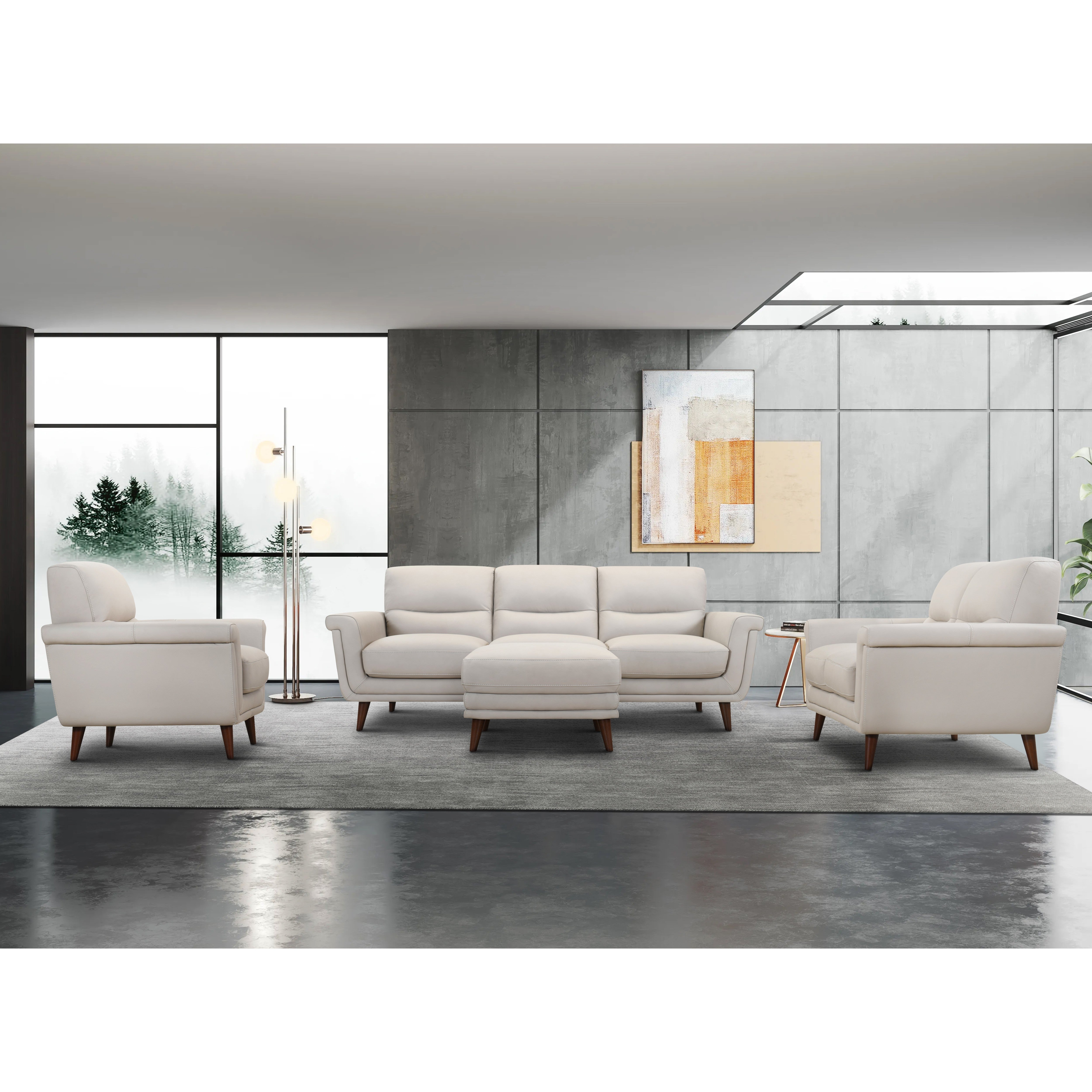 Modern living room with cream-colored sofa set and large windows.