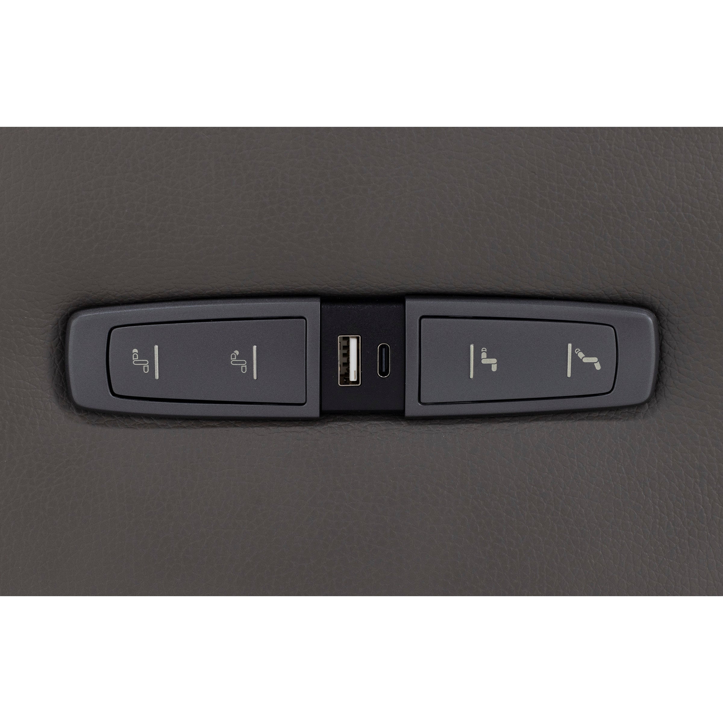 Control panel with USB and USB-C ports for seat adjustments on a dark leather surface.