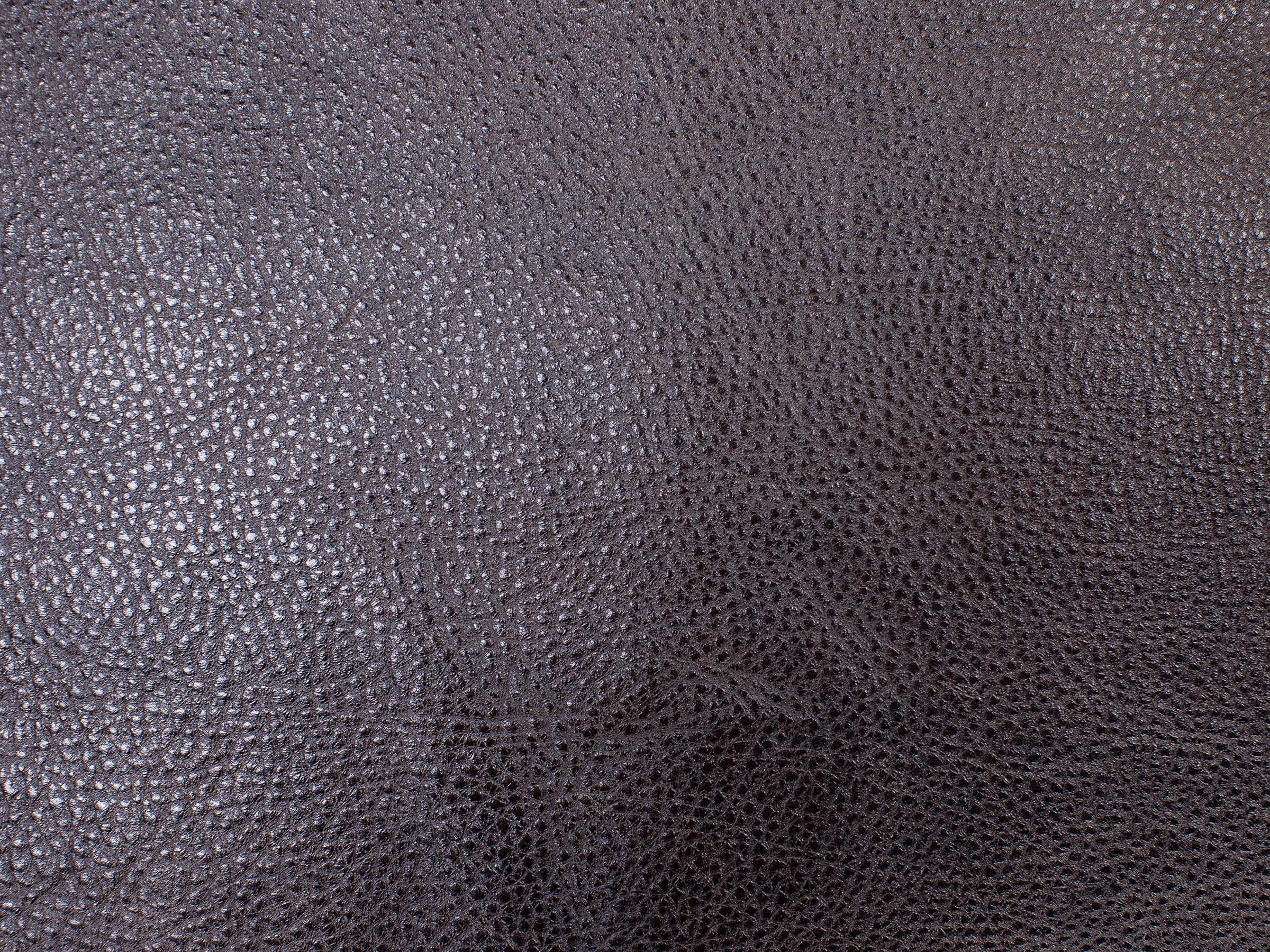 Close-up of dark brown textured leather material.