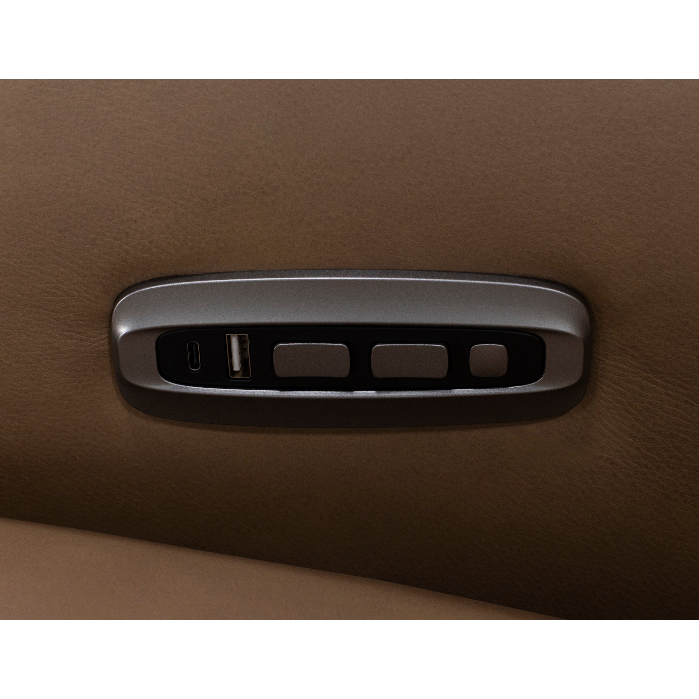 Close-up of car seat controls with USB ports on tan leather.