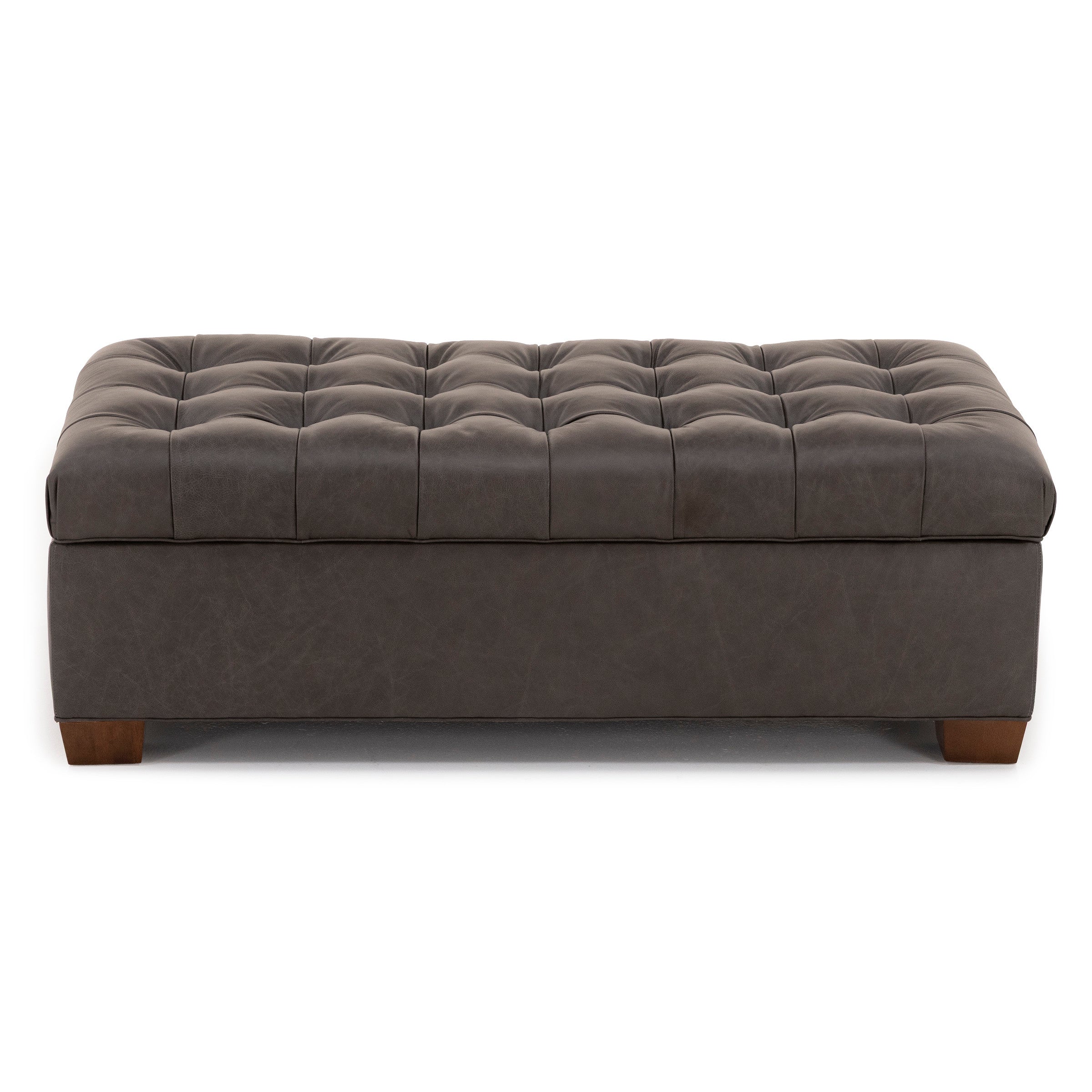 Dark gray tufted ottoman with wooden legs, front view.