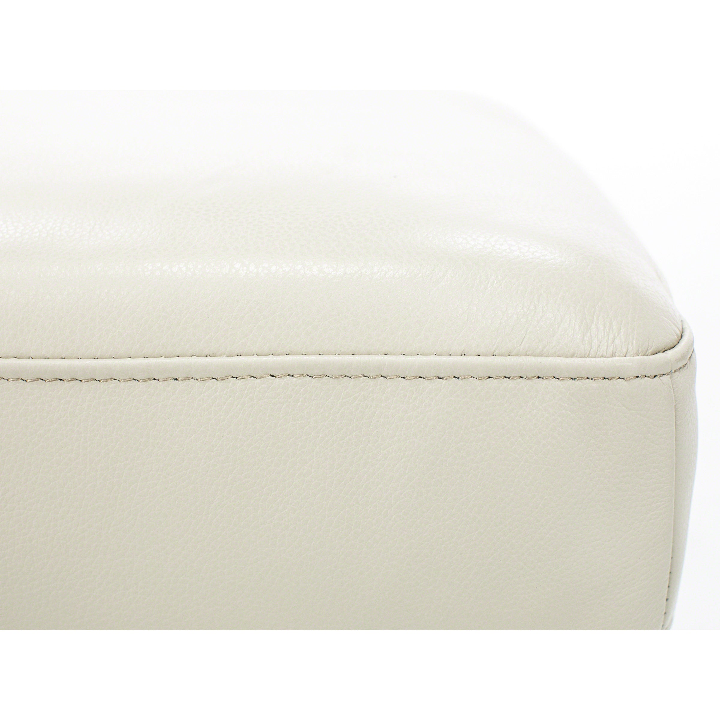 Close-up of beige leather upholstery with visible stitching.