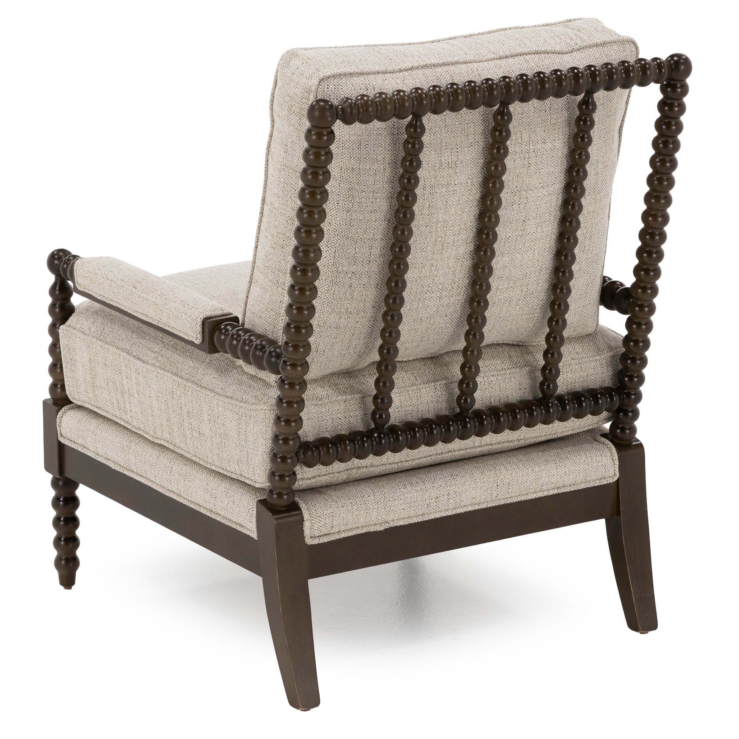 Back view of a beige cushioned accent chair with dark wood frame and spindle detailing.