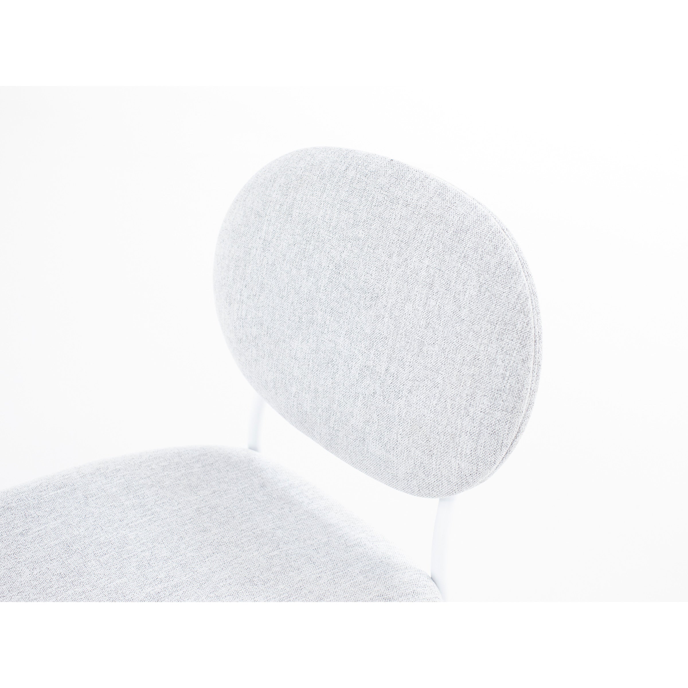 Close-up of a light gray cushioned chair with a rounded backrest.