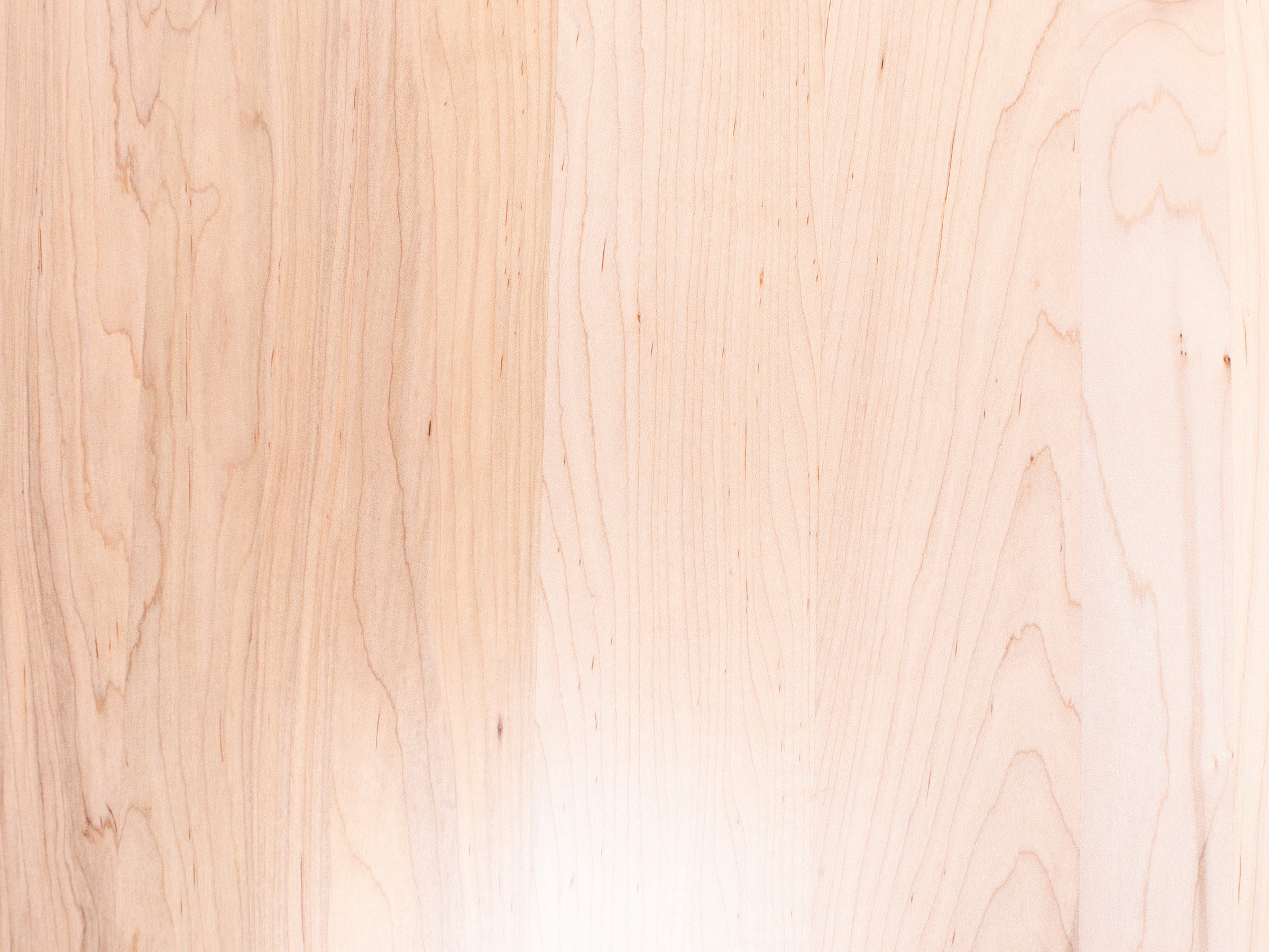 Light maple wood surface with natural grain pattern.