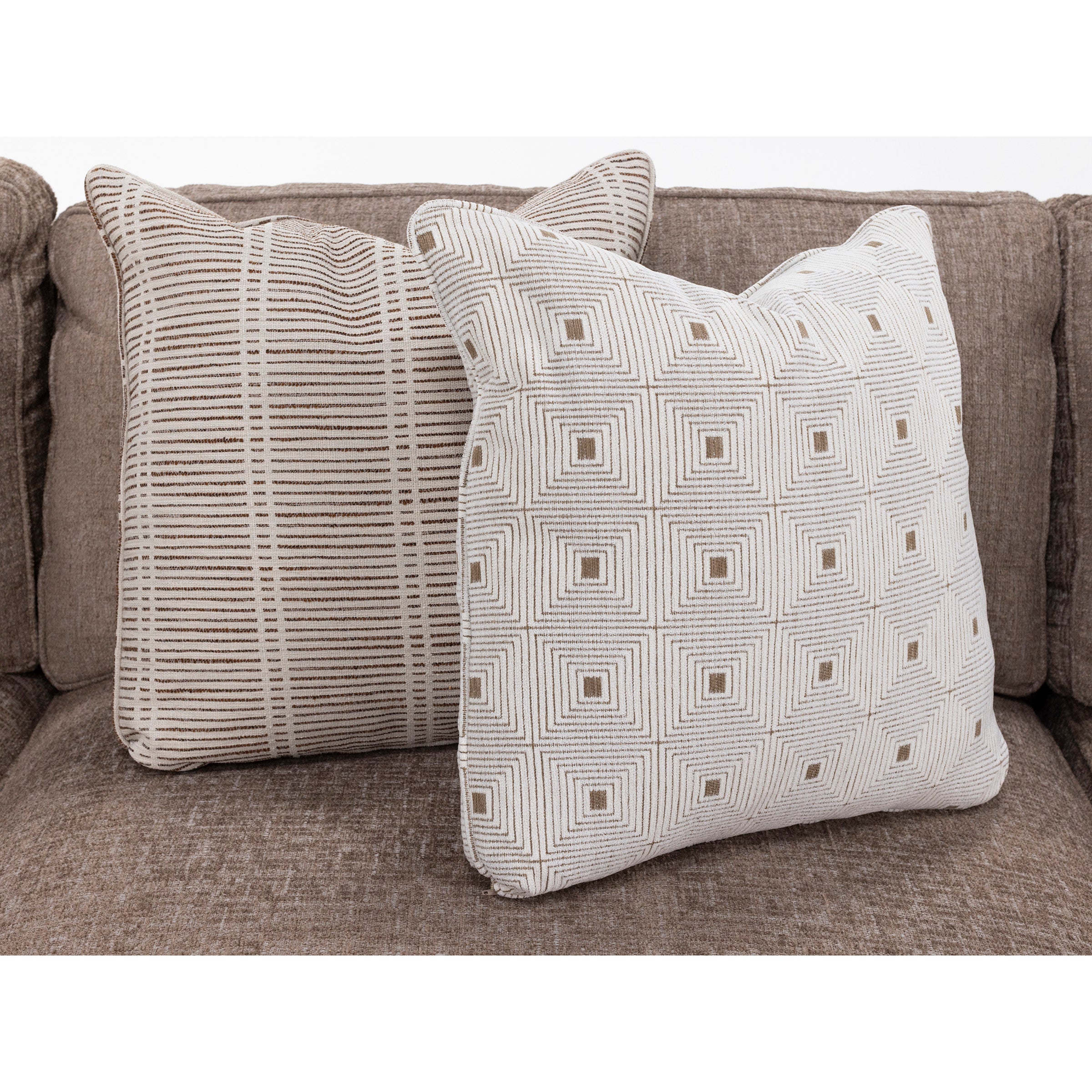 Two patterned throw pillows on a brown sofa.
