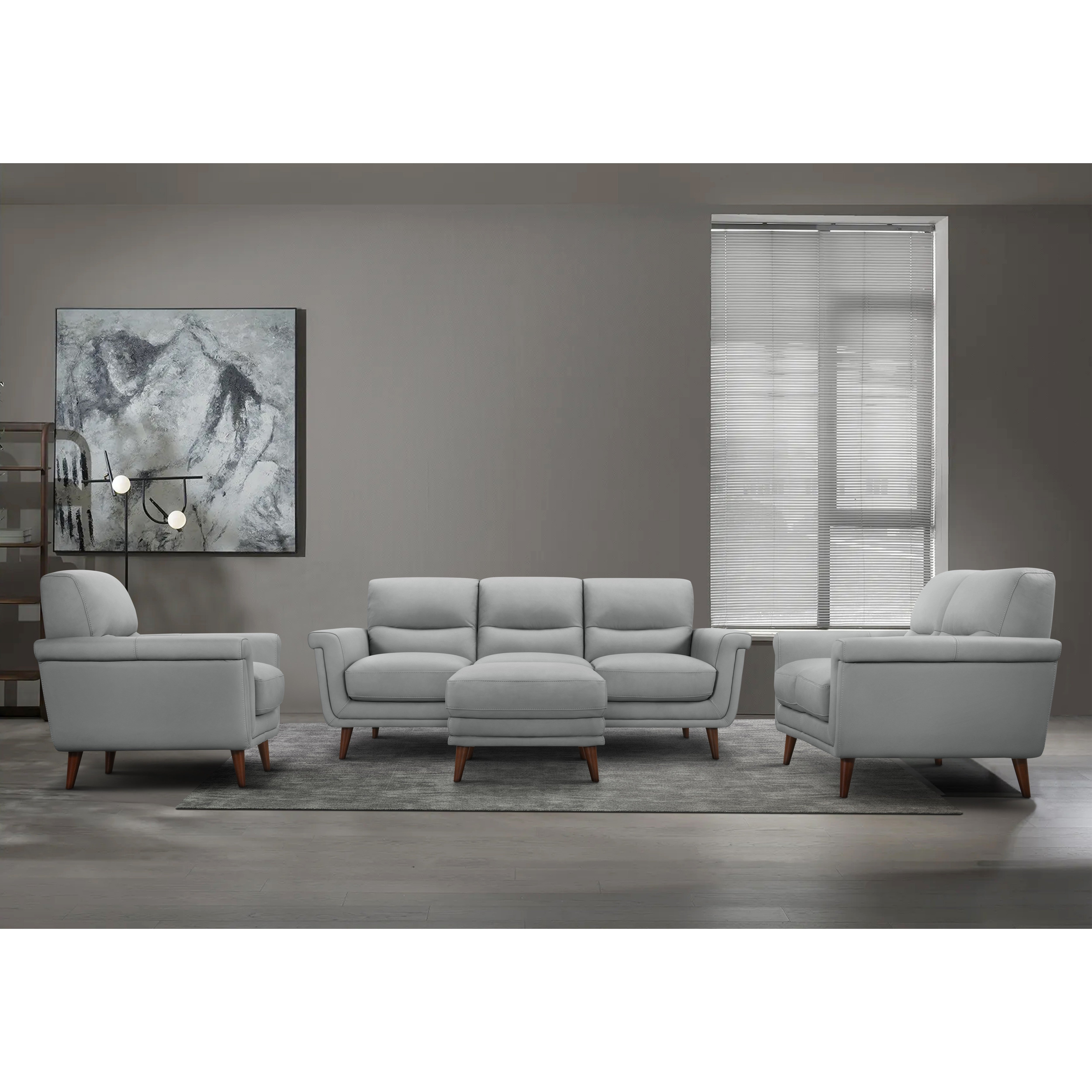 Modern gray living room set with sofa, chairs, and ottoman on a rug.