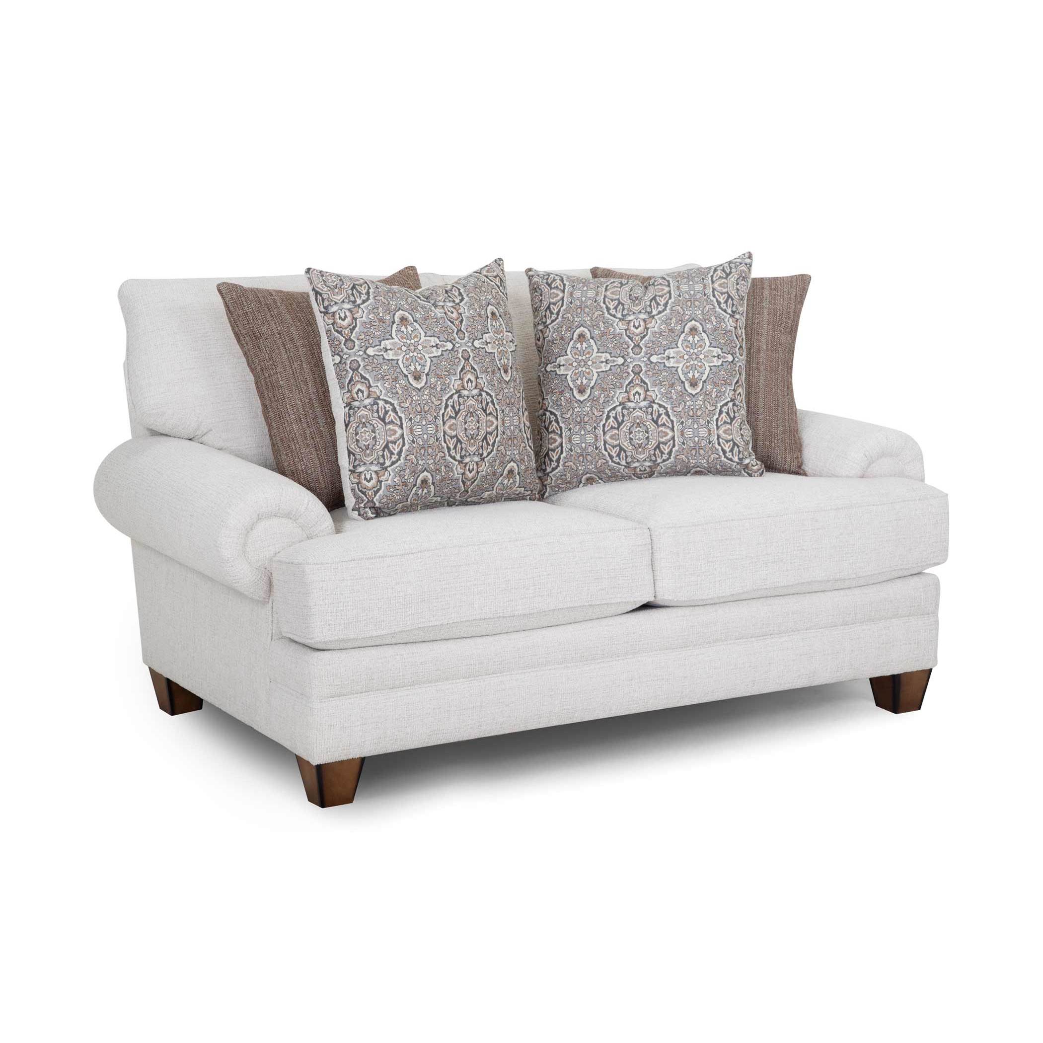 Light beige loveseat with rolled arms and four decorative pillows in brown and patterned fabric.
