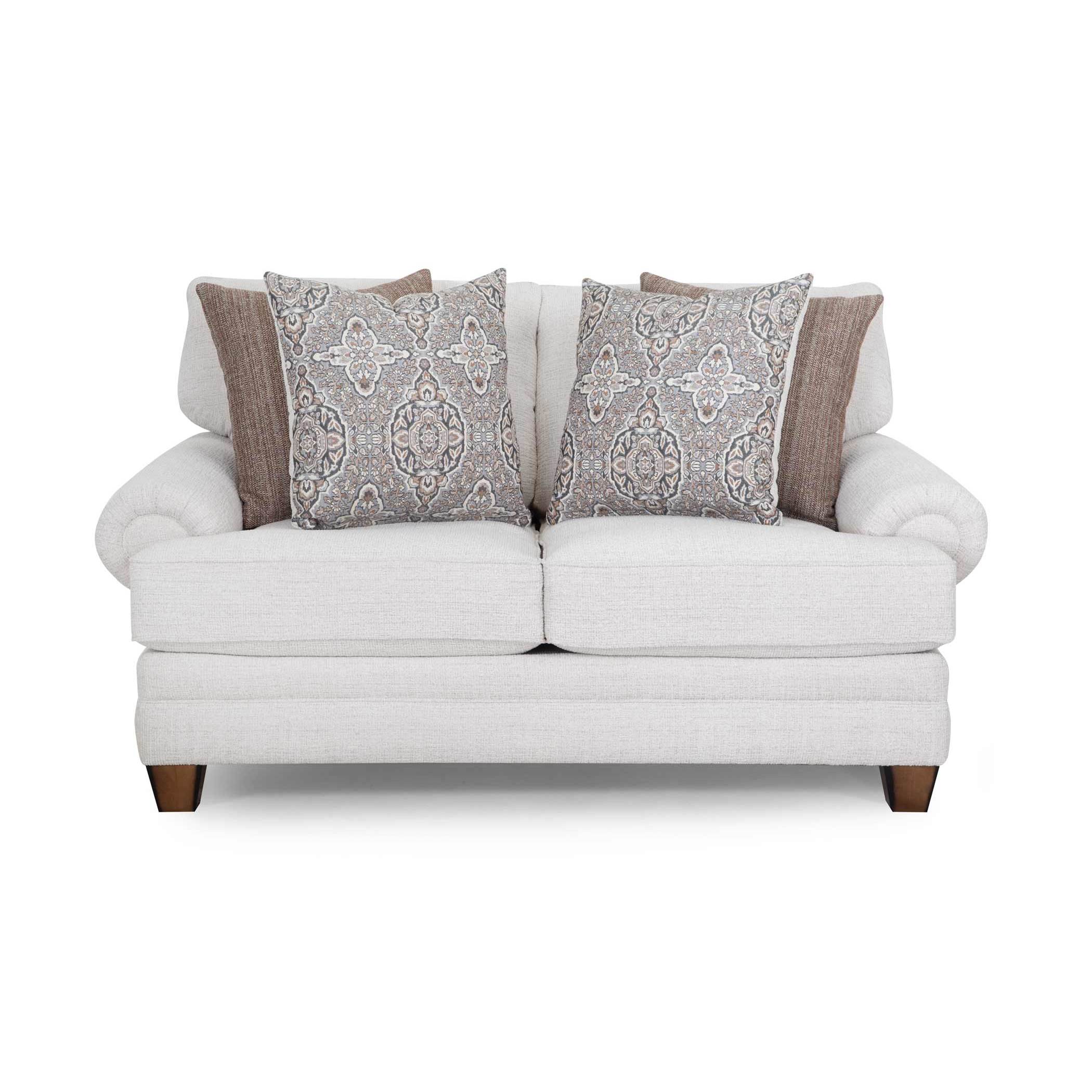 Light beige loveseat with rolled arms and four patterned throw pillows.