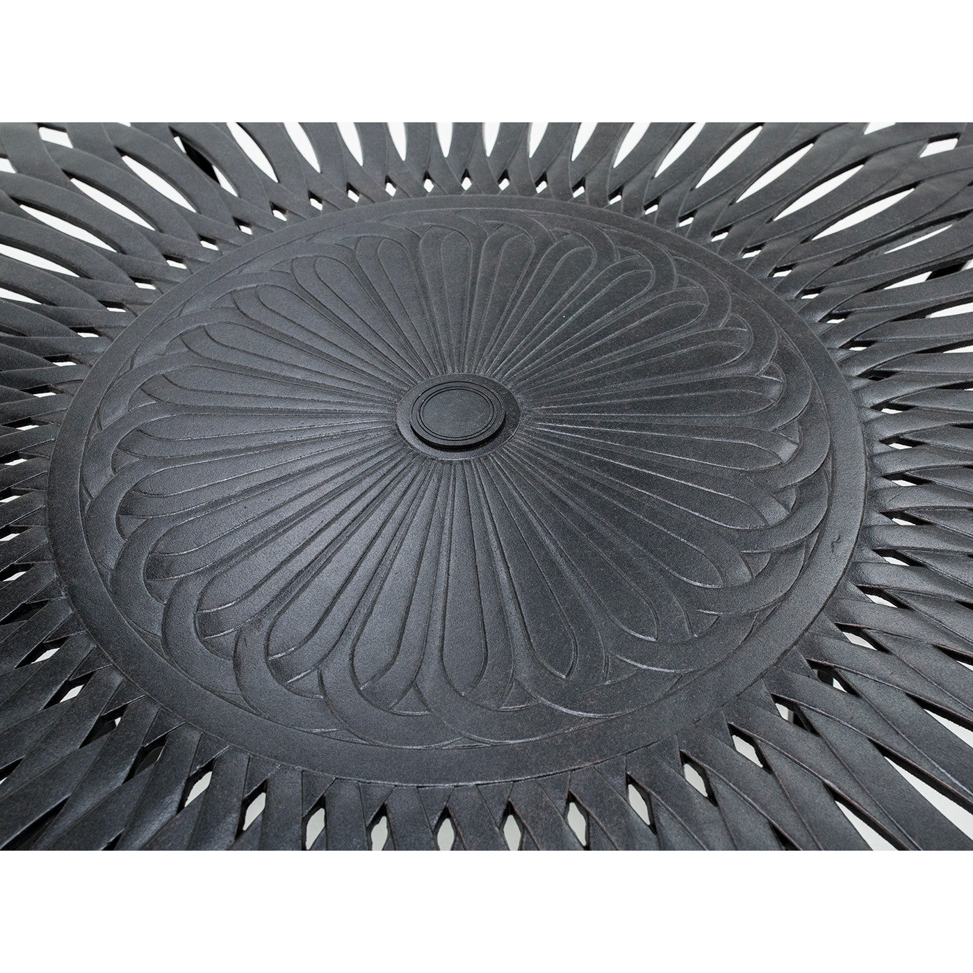 Close-up of a decorative black metal table top with intricate cut-out pattern.