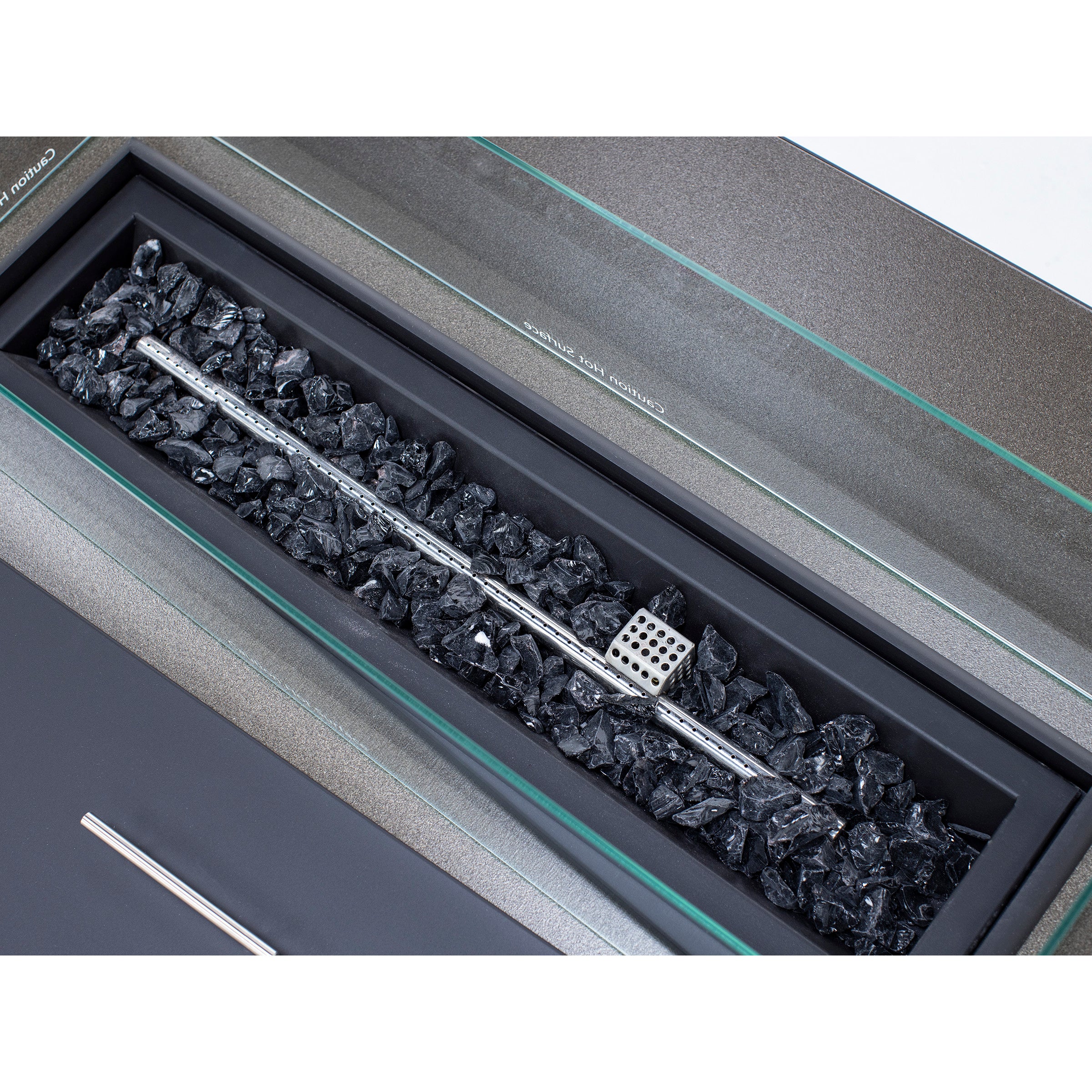 Rectangular gas fireplace burner with black decorative stones and metal grate.