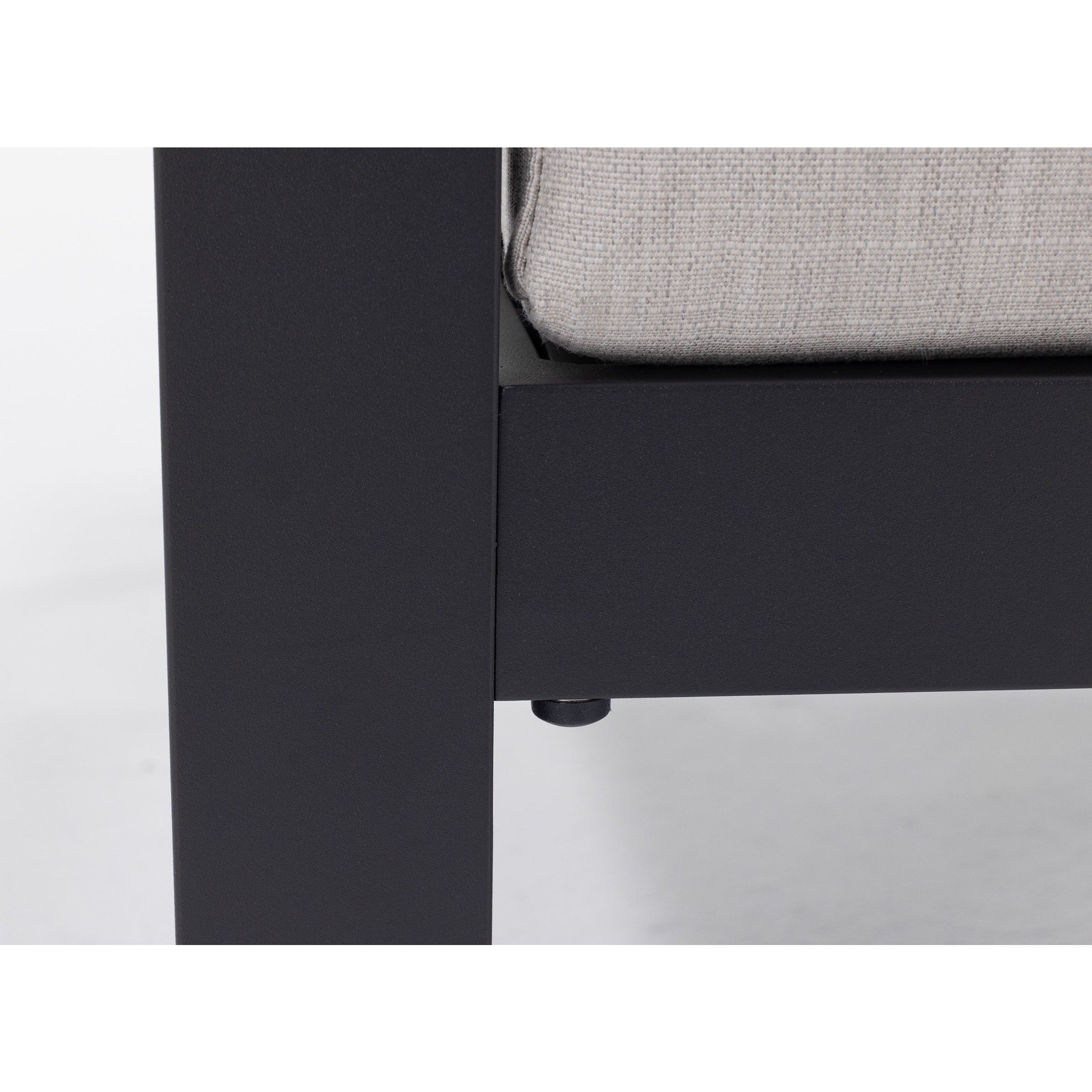 Close-up of a black metal furniture frame corner with a light gray cushion.