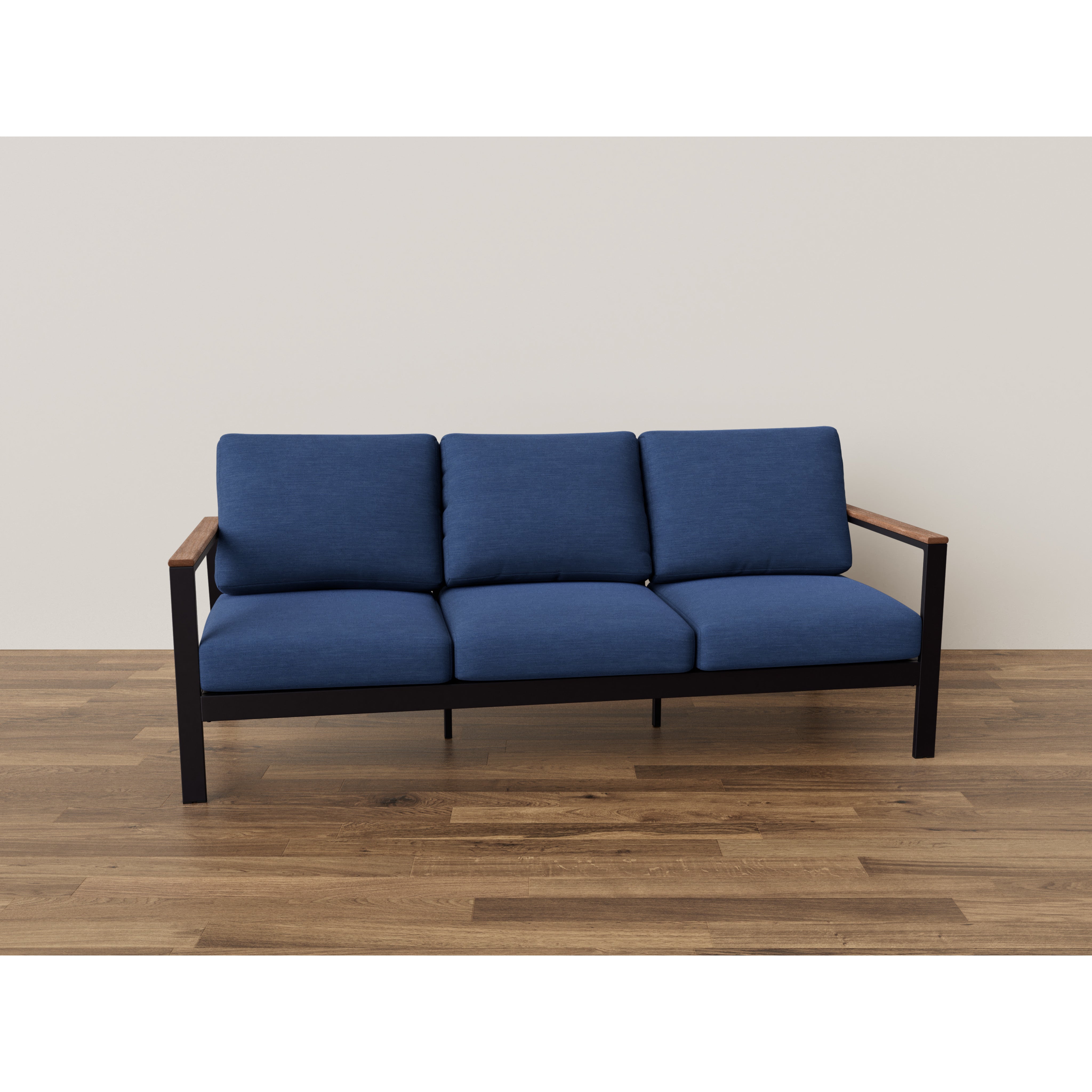 Three-seat blue sofa with wooden arms on a wood floor against a plain wall.