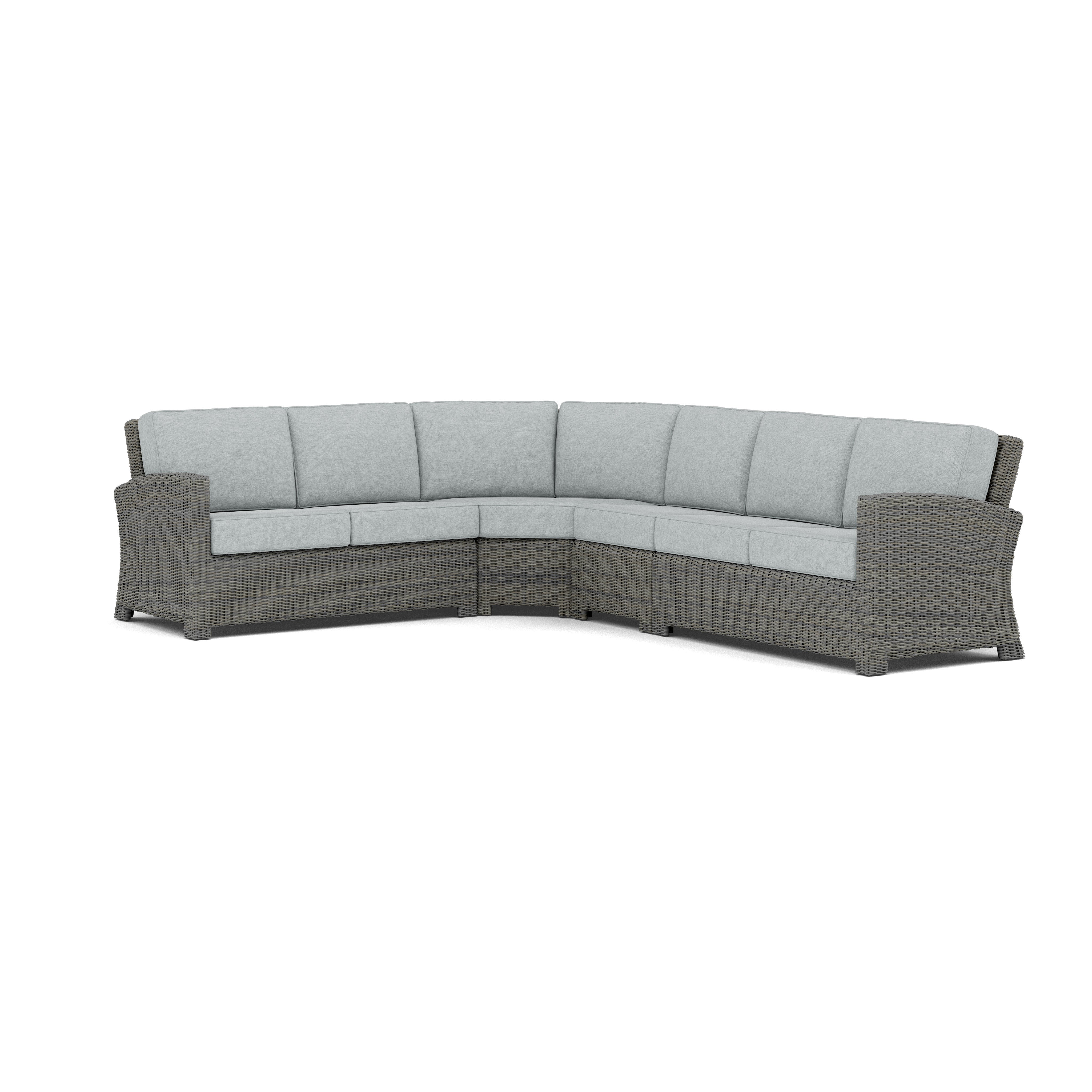 Gray outdoor sectional sofa with thick light gray cushions, curved for corner seating.