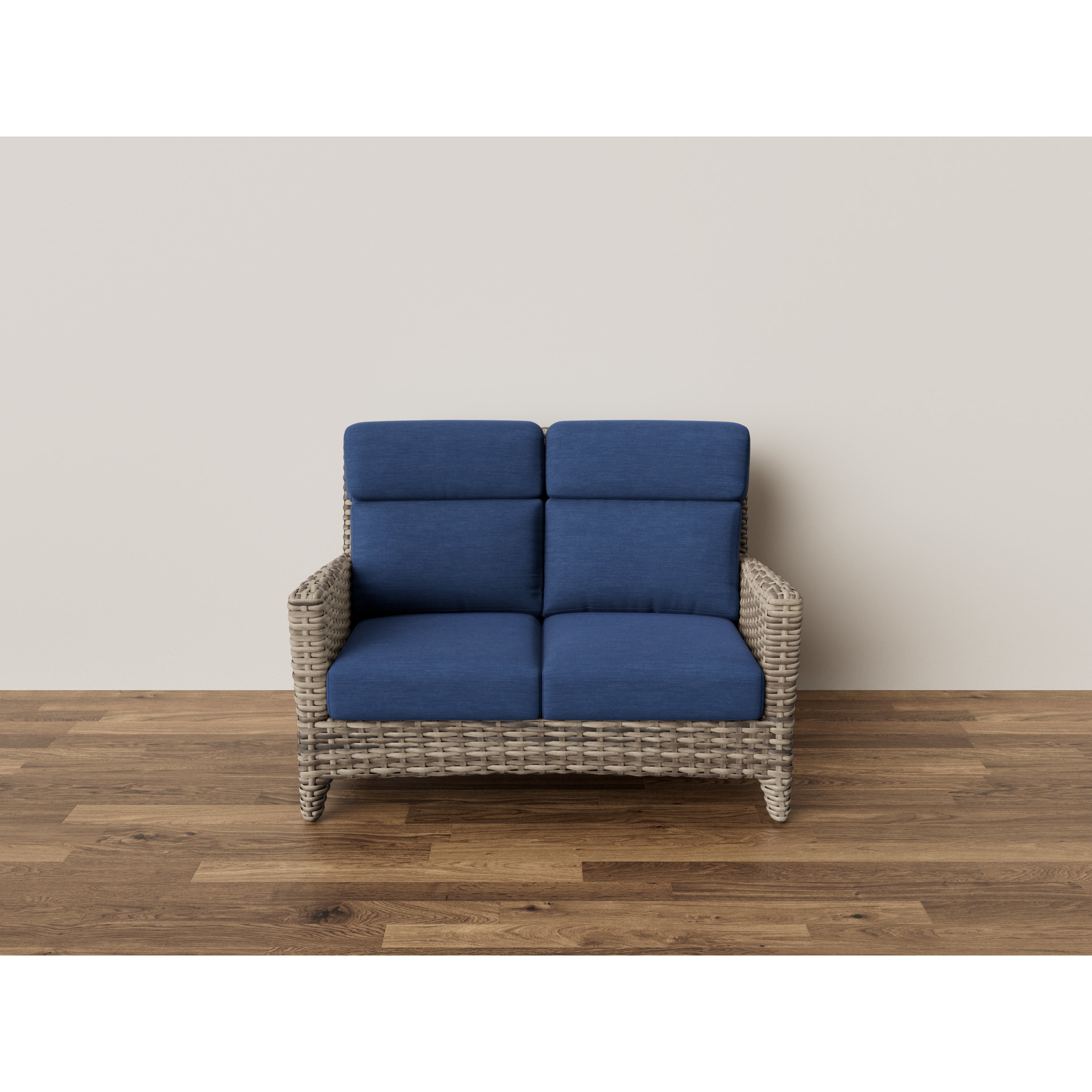 Wicker loveseat with blue cushions on wooden floor against a plain wall.