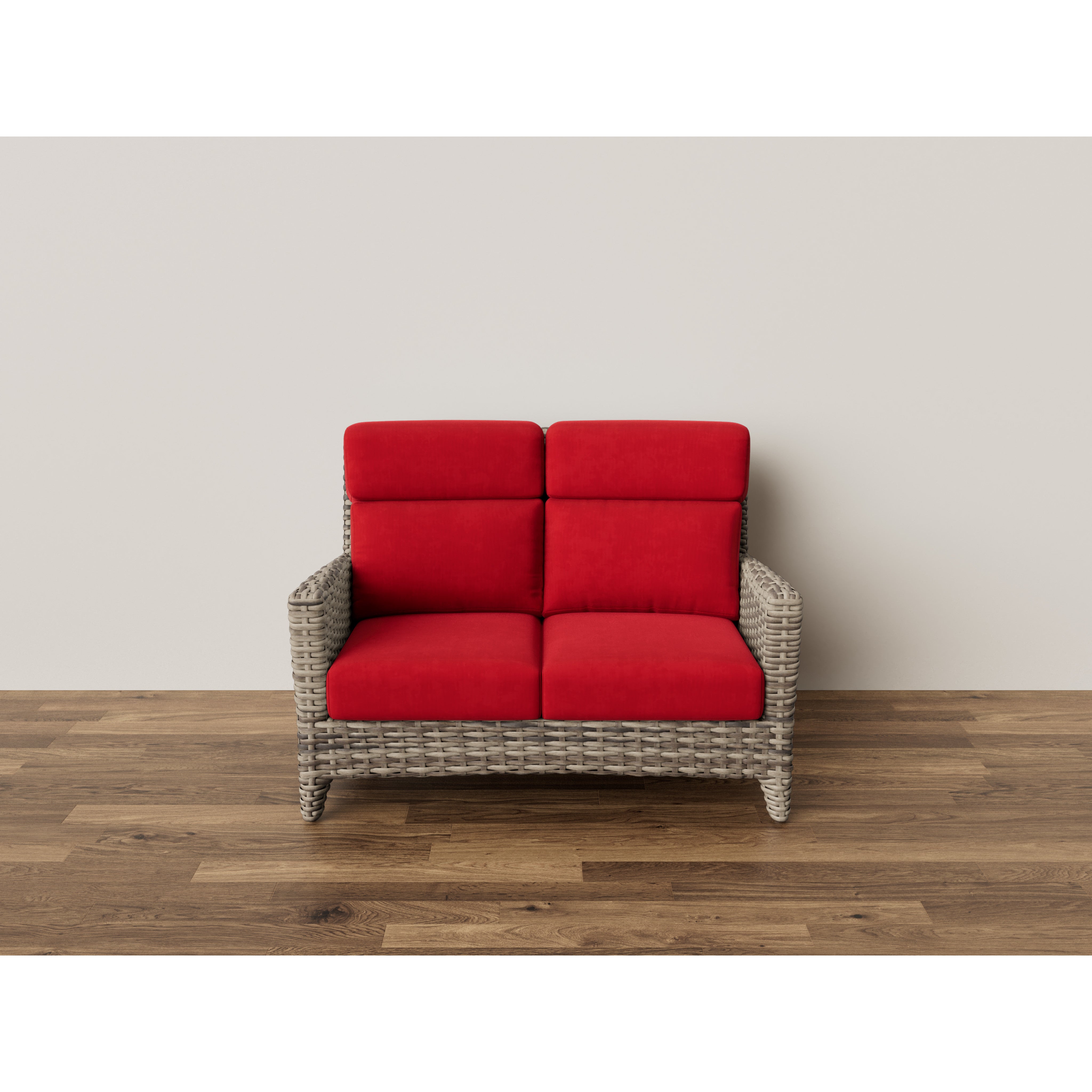 Wicker loveseat with bright red cushions on wood flooring against a plain wall.