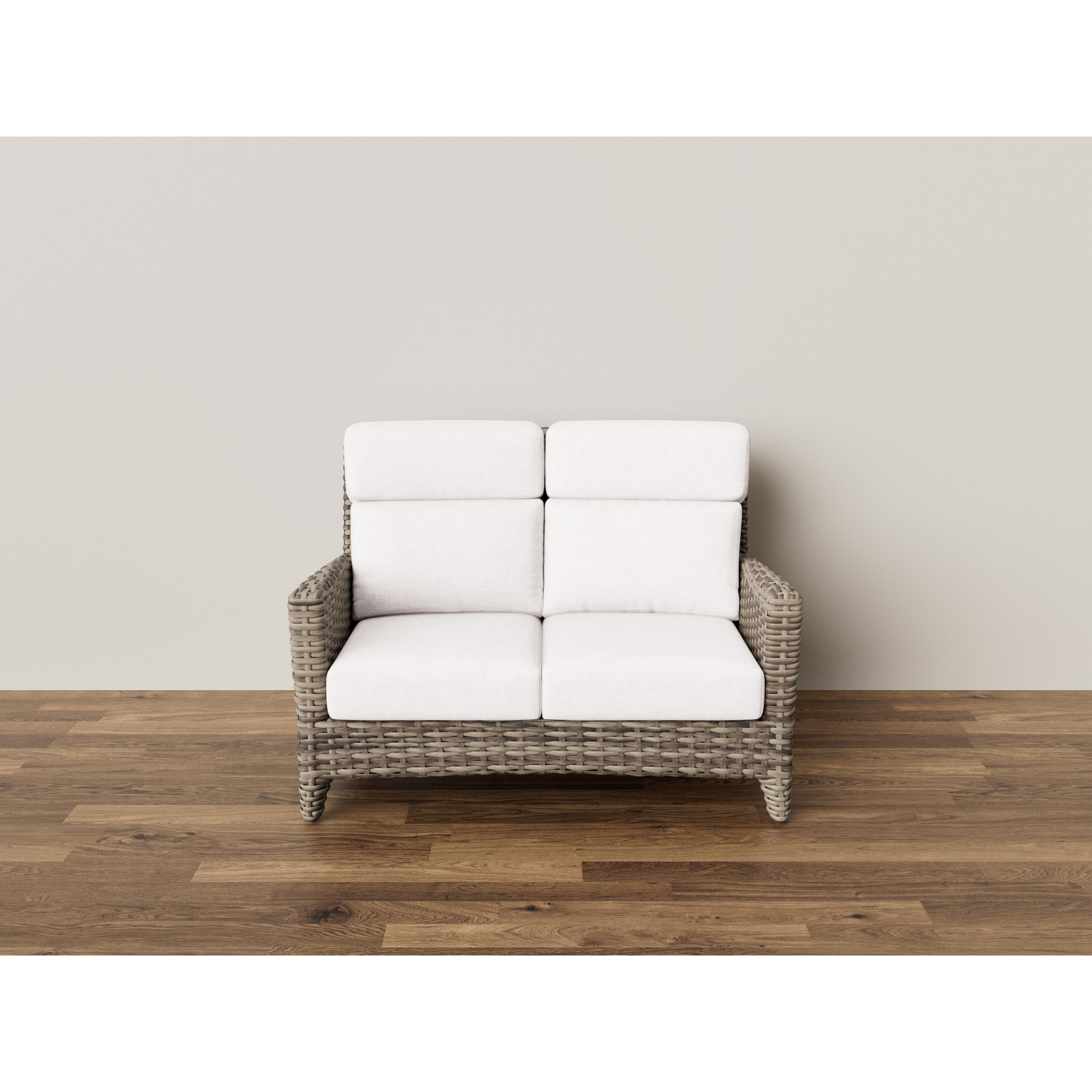 Wicker loveseat with white cushions on wood floor, neutral background
