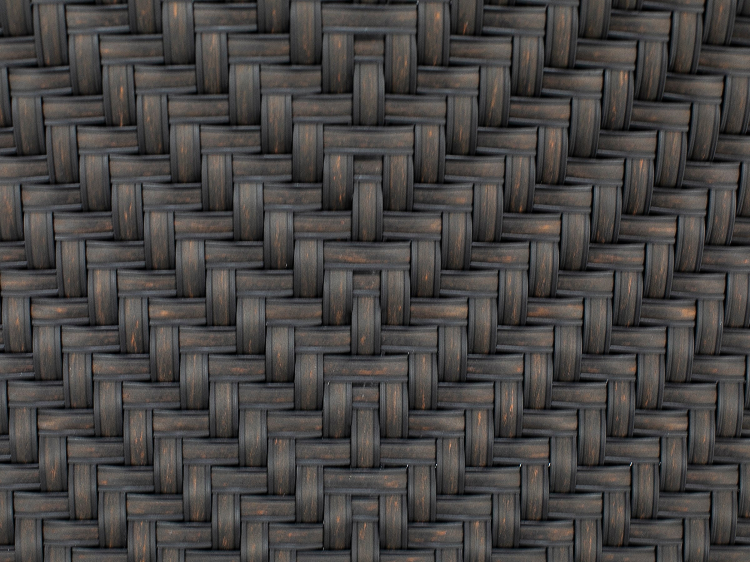 Close-up of dark brown woven rattan pattern, often used in outdoor furniture.