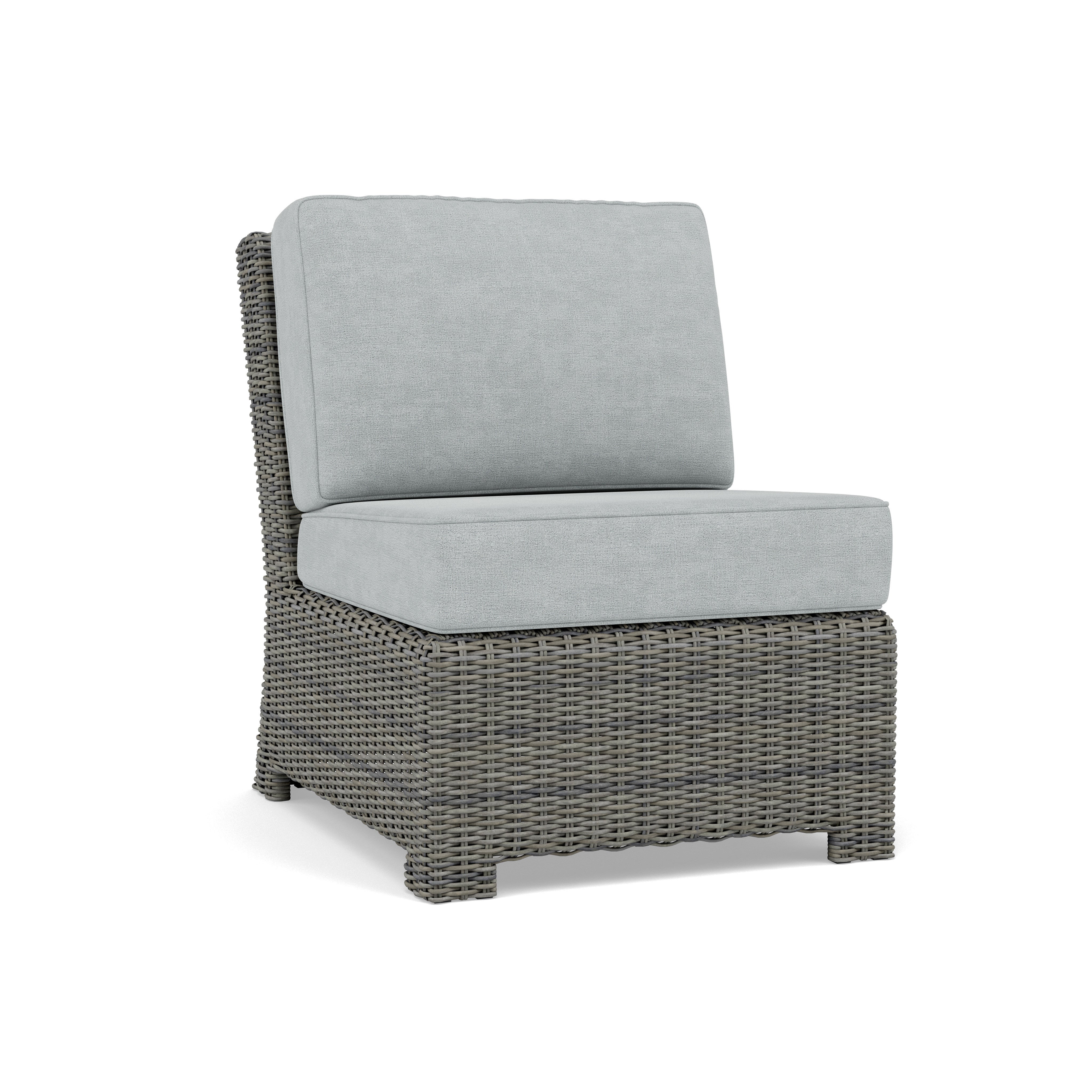 Armless outdoor chair with light gray cushions and woven rattan base.