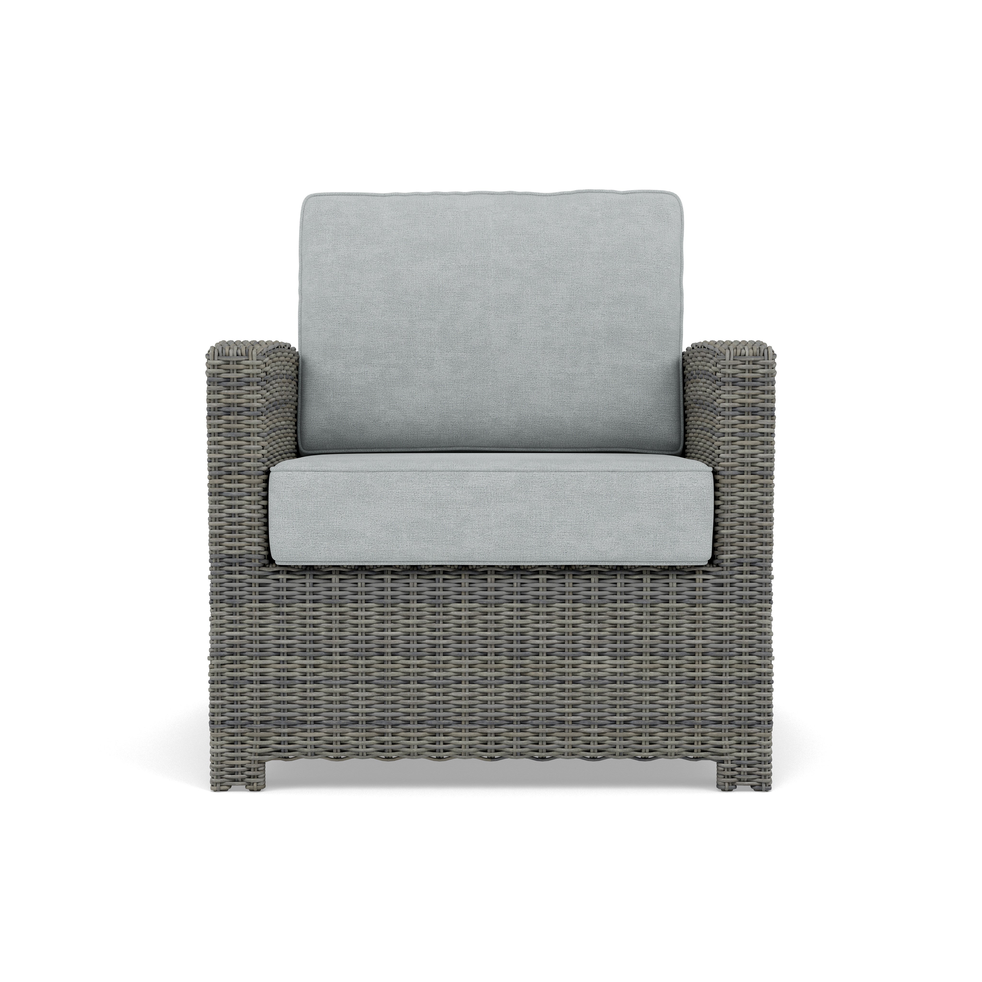 Front view of a gray wicker armchair with light gray cushions.