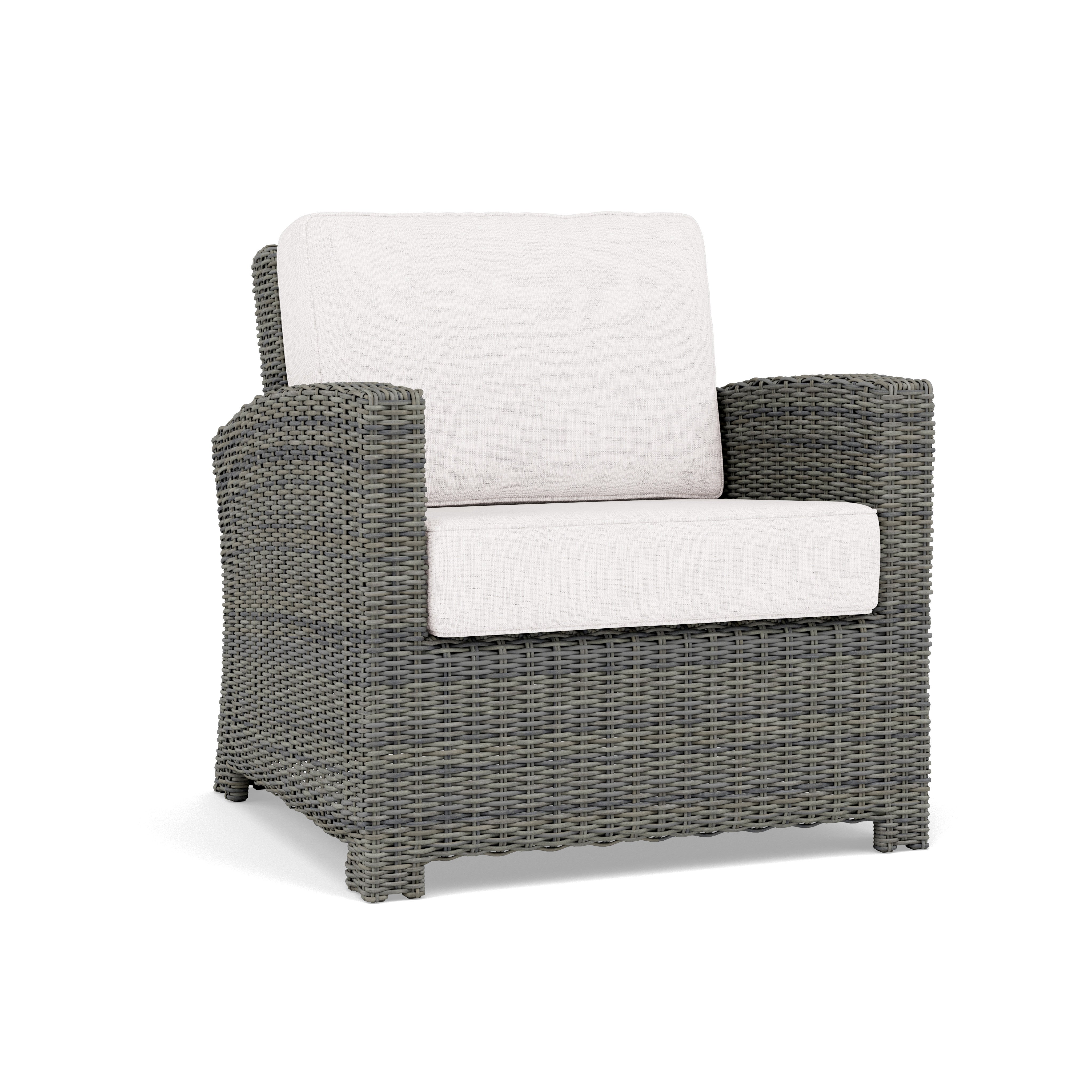 Gray woven outdoor armchair with white cushions.