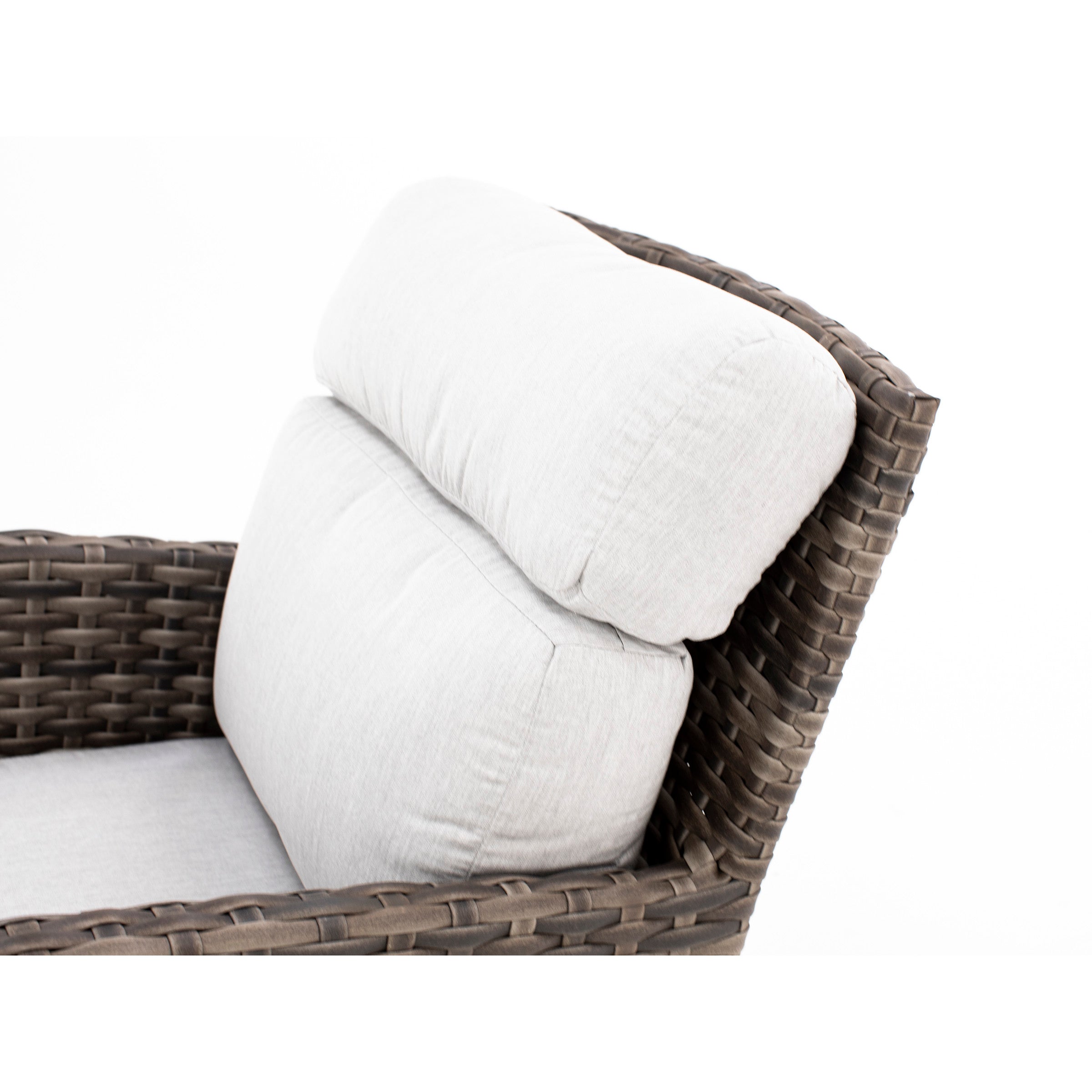 Close-up of a wicker chair with light gray cushions.