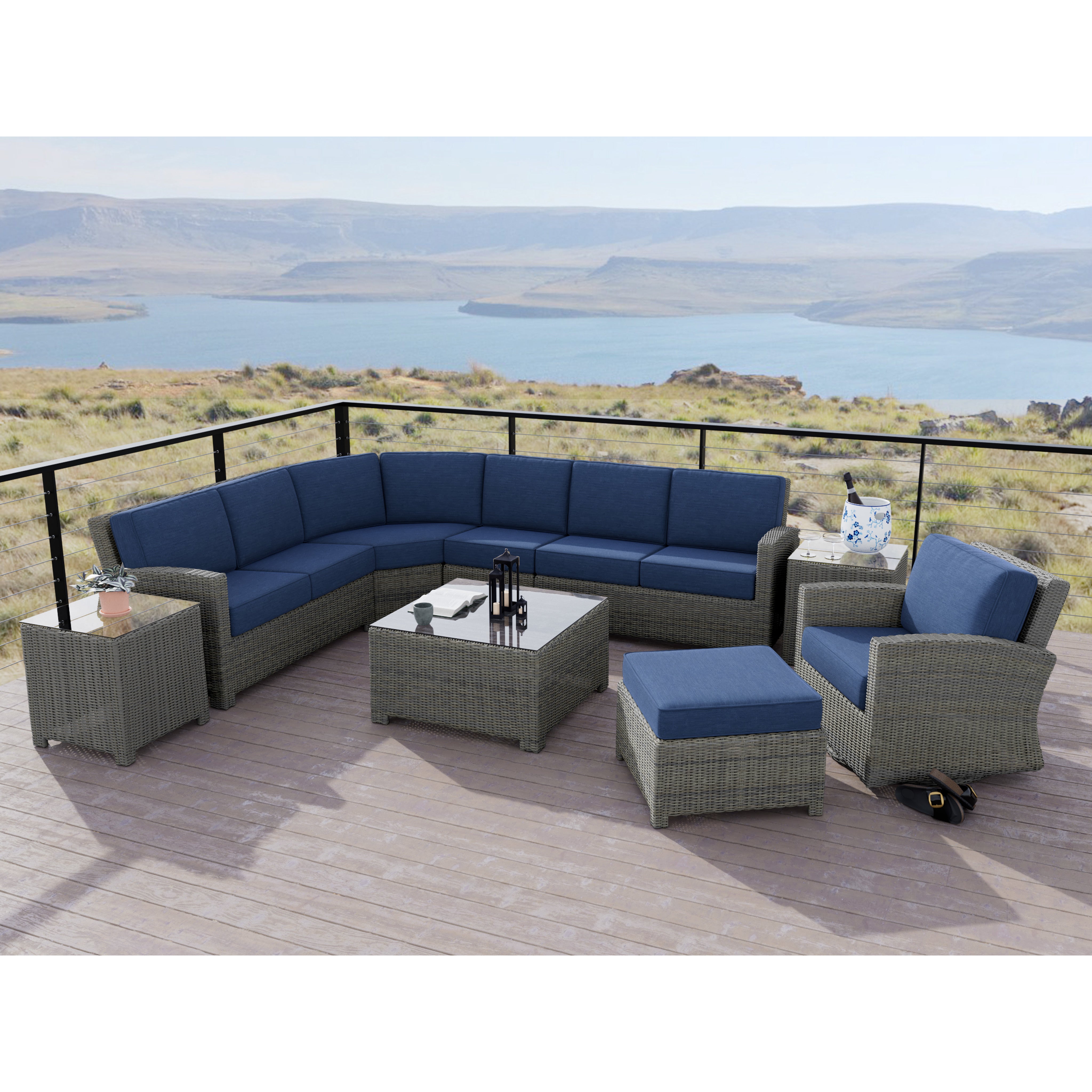 Outdoor patio seating set with blue cushions on a deck overlooking a scenic lake and hills.