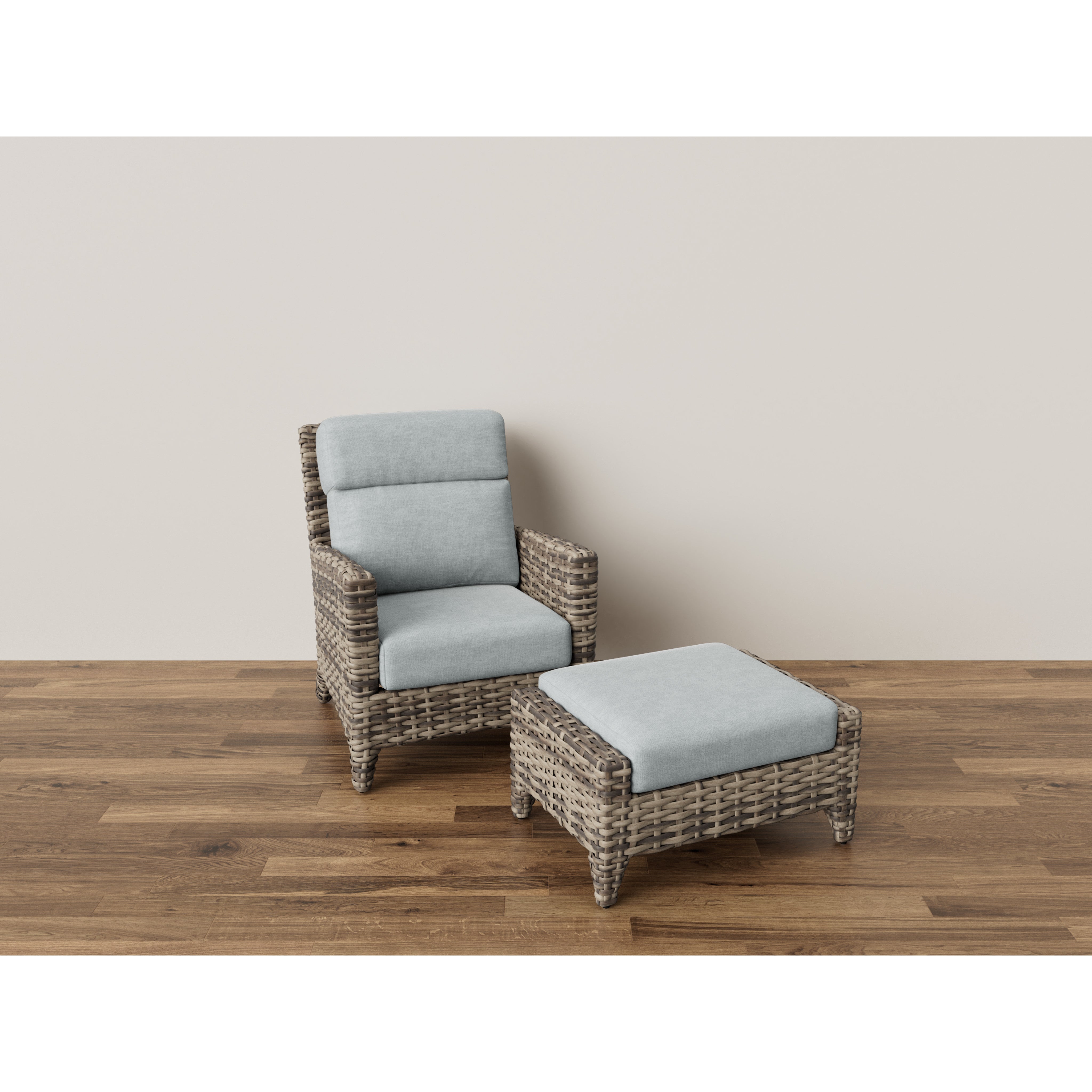 Wicker armchair with light gray cushions and matching ottoman on wood floor.