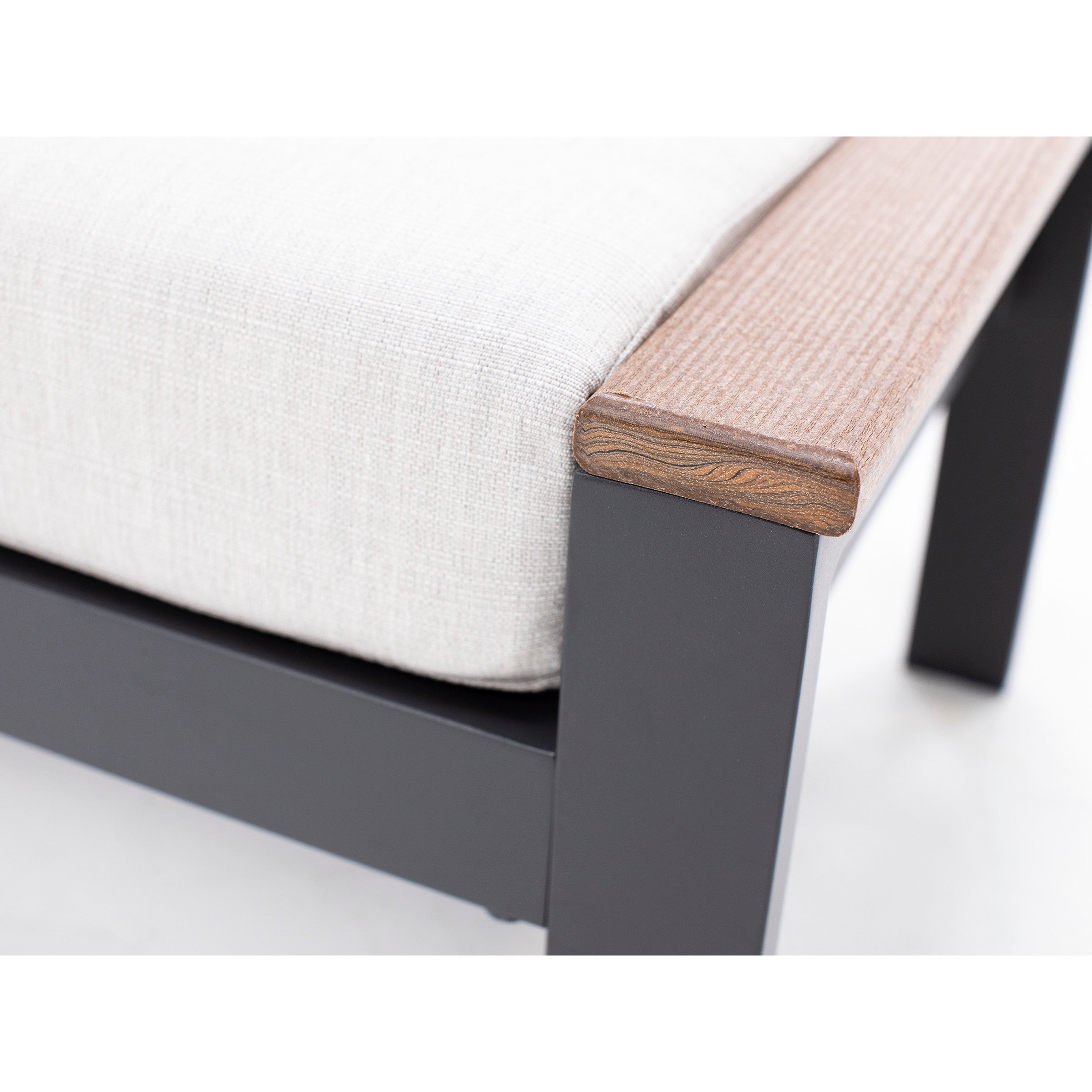 Close-up of a chair armrest with wood finish and light fabric cushion.