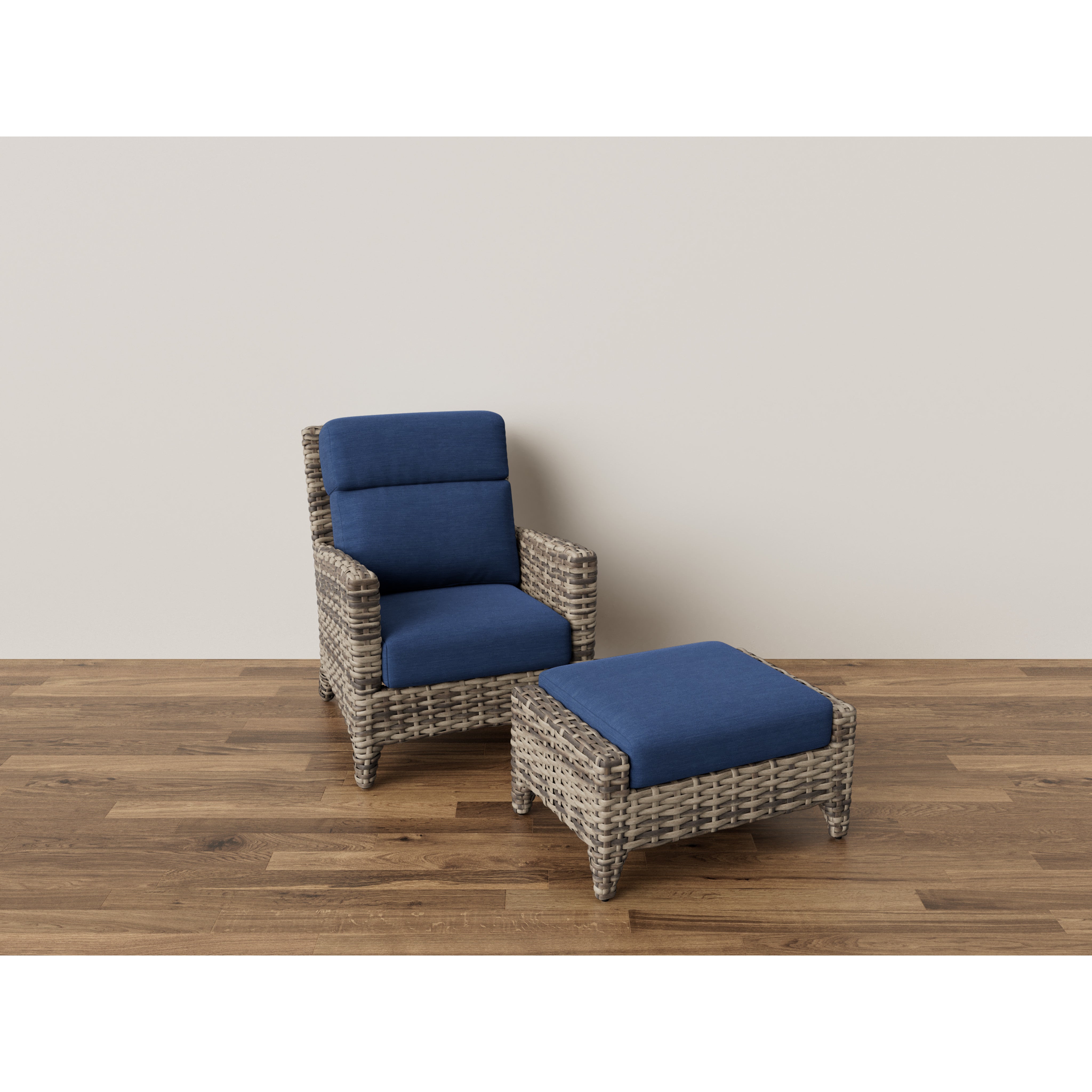 Wicker armchair with blue cushions and matching ottoman on wood floor.