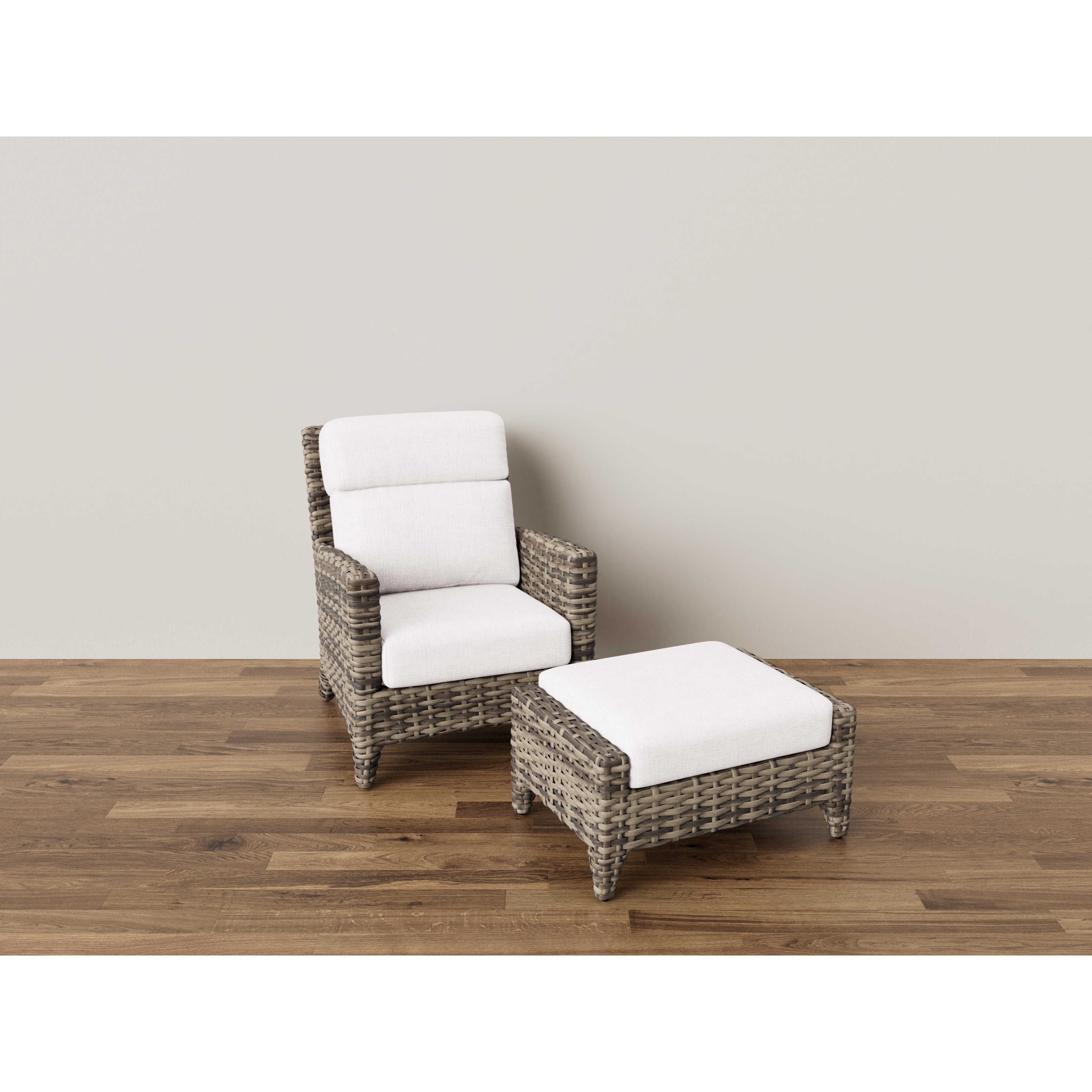 Wicker armchair with white cushions and matching ottoman on wood floor.