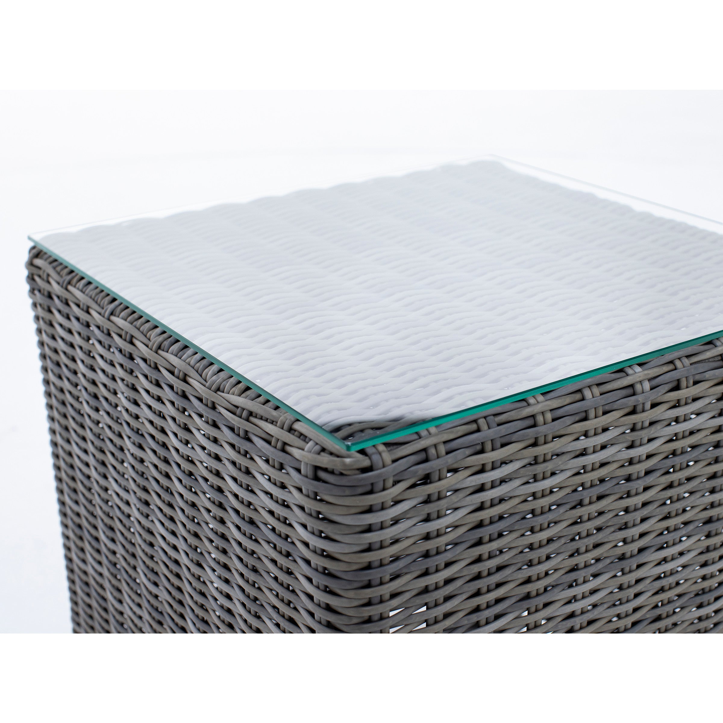 Close-up of a square wicker table with a glass top.