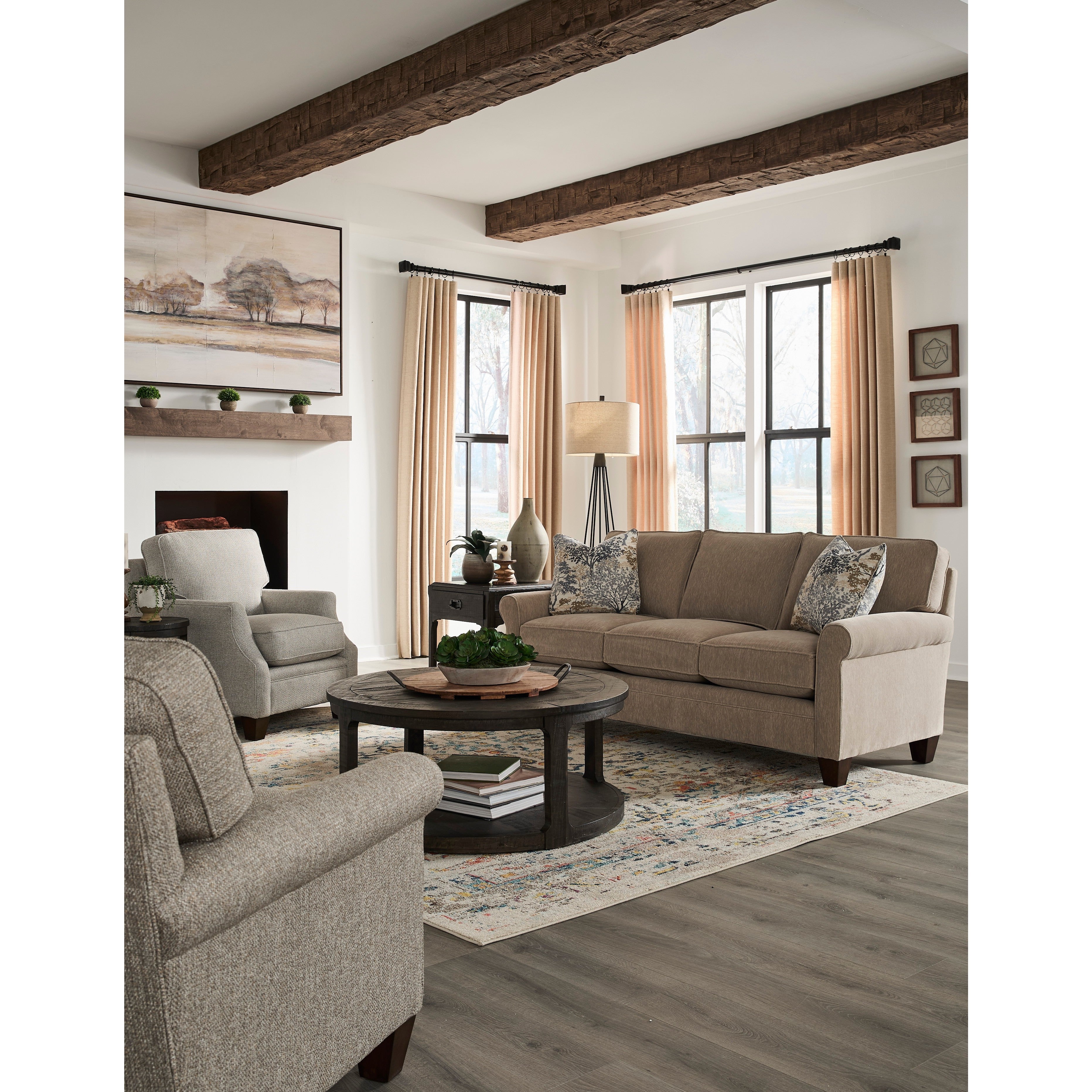 Neutral-toned living room with sofa, chairs, coffee table, and large windows.