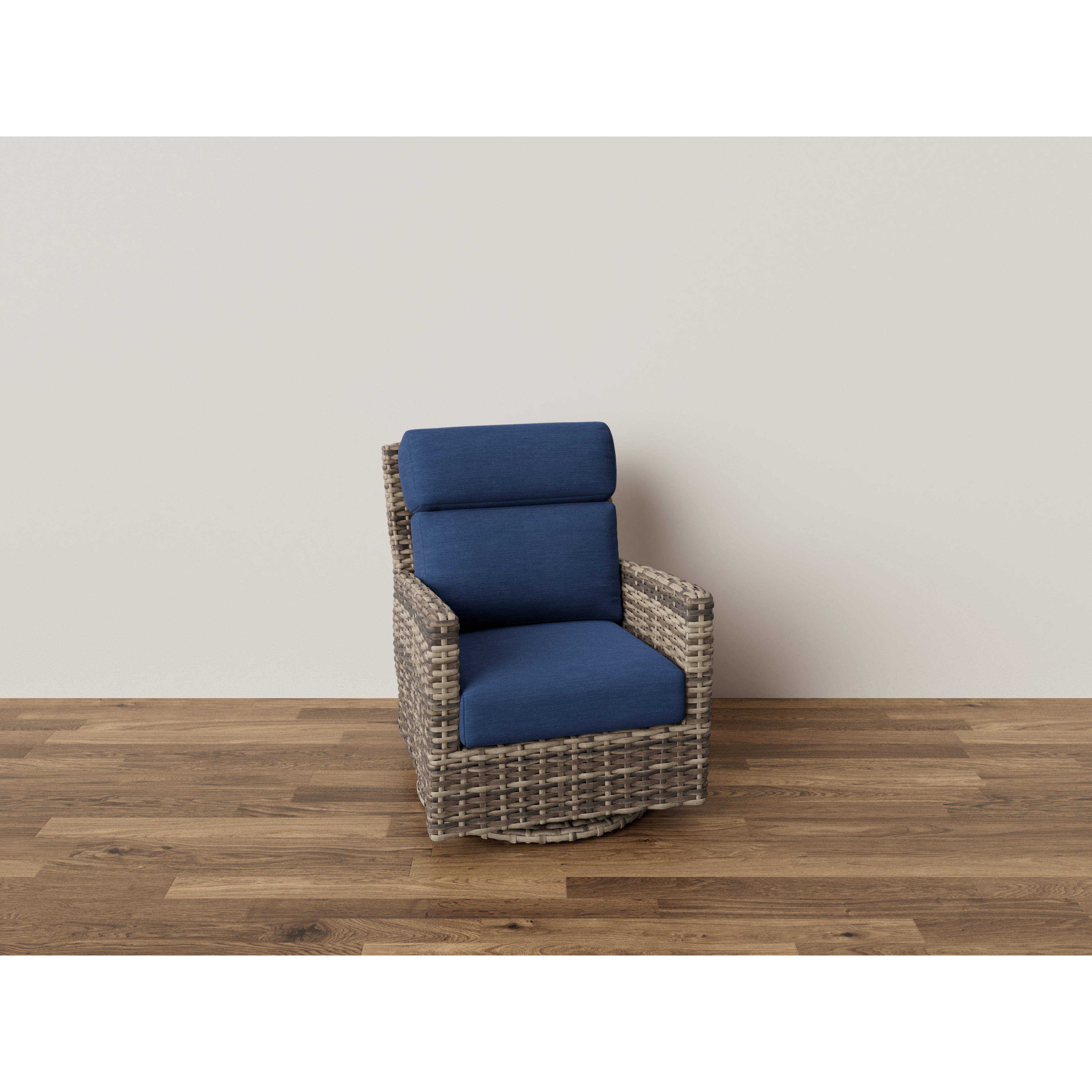 Wicker swivel chair with blue cushions on wood floor against light wall.
