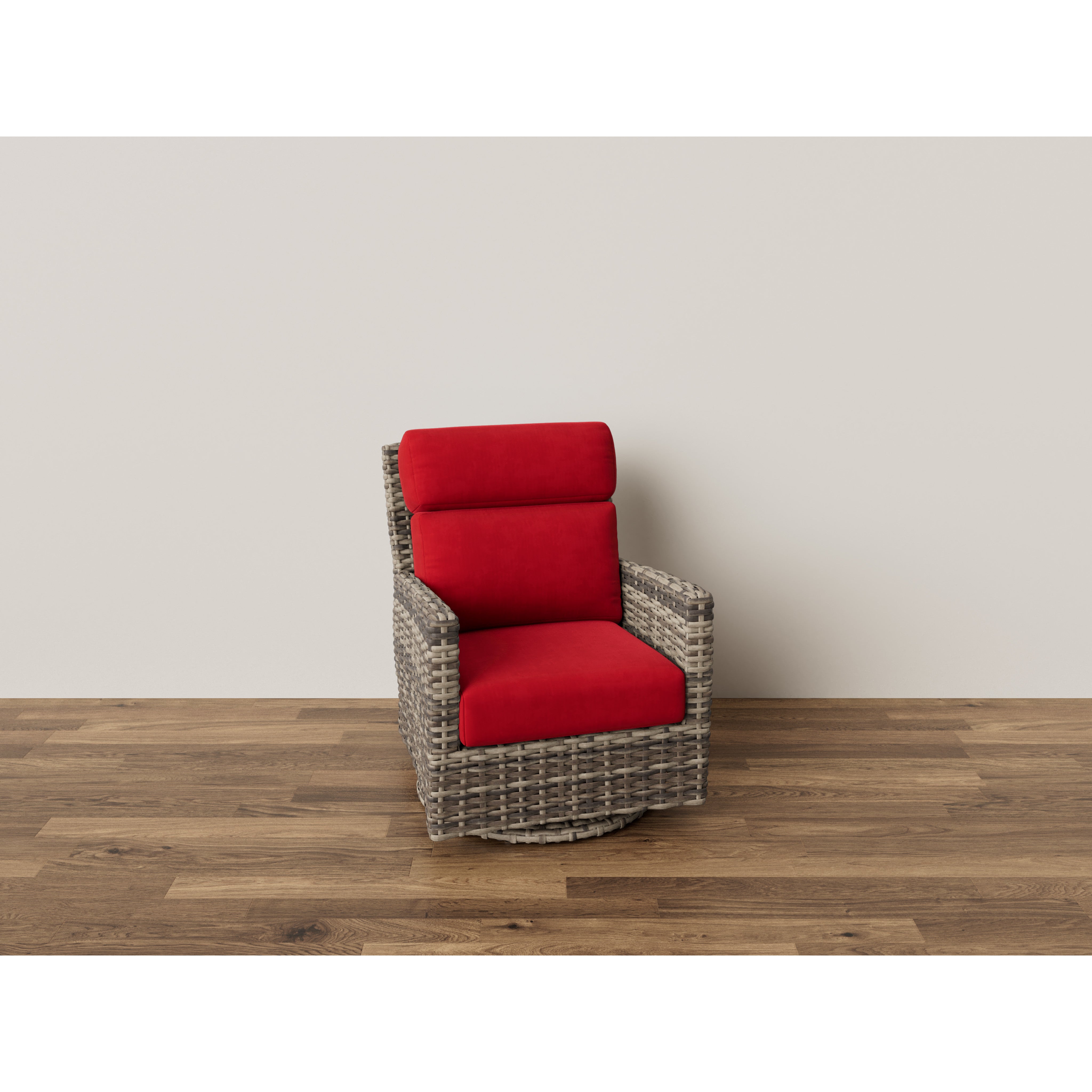 Wicker armchair with red cushions on wooden floor against a plain wall.